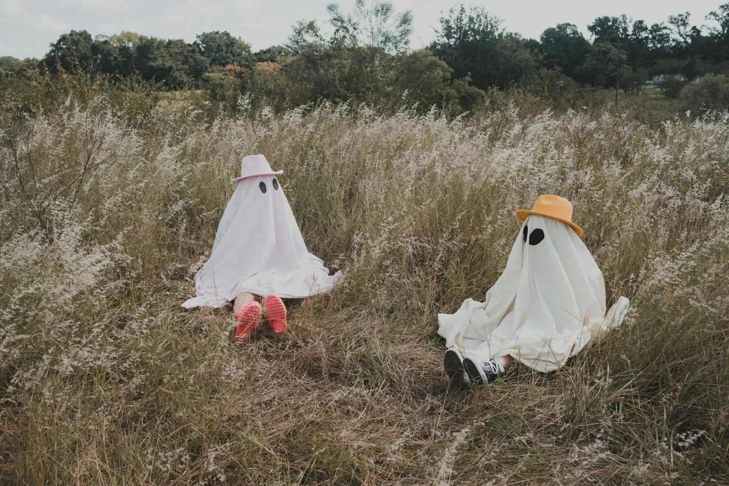 People dressed as ghosts sitting in a field