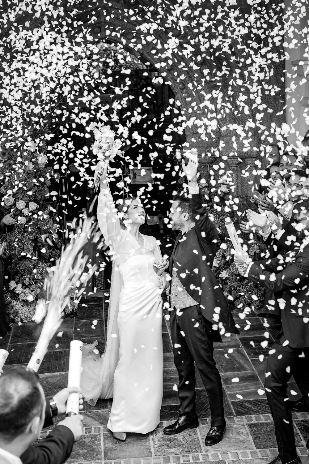 A bride and groom celebrating with confetti falling