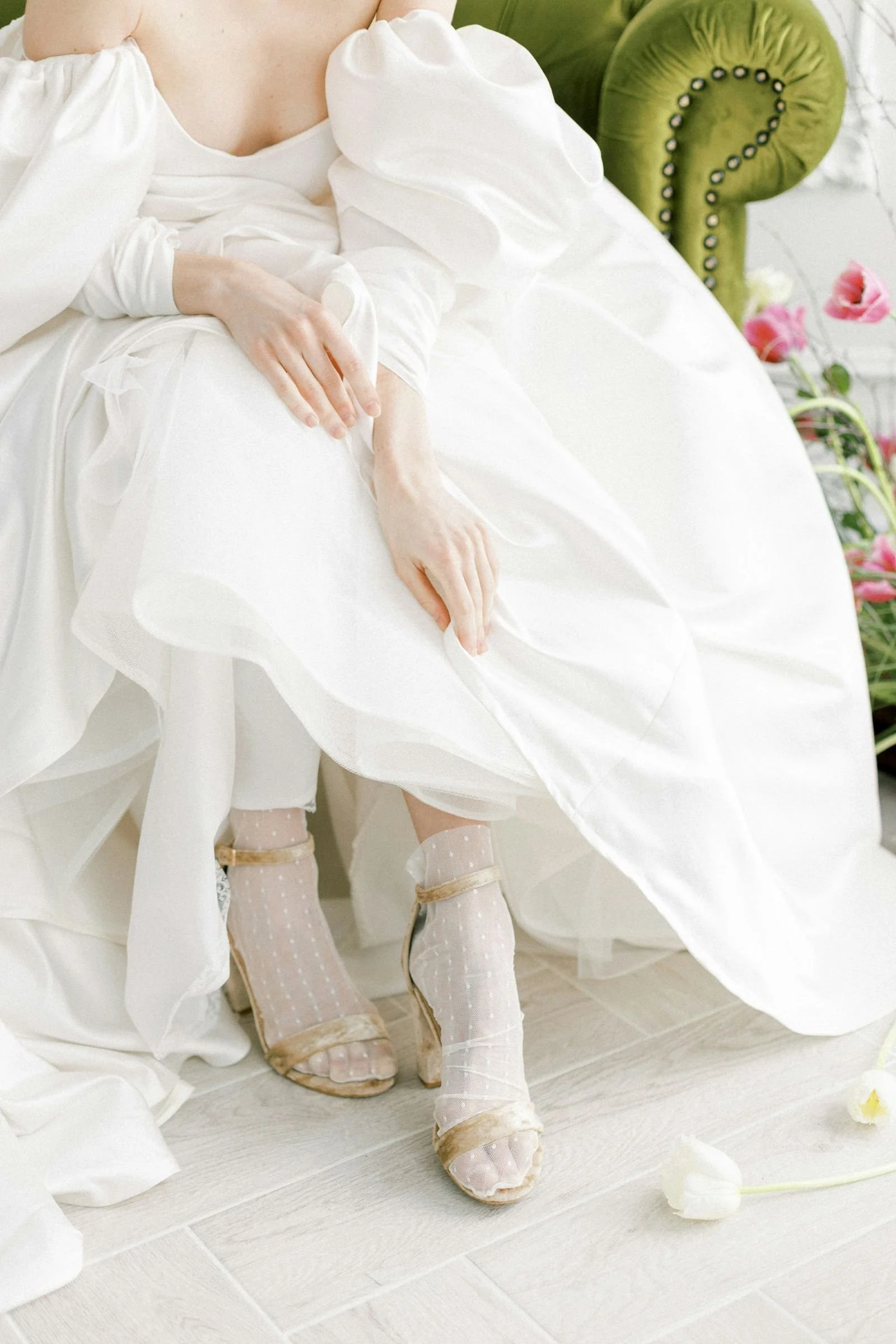 A bride sitting on a green velvet couch