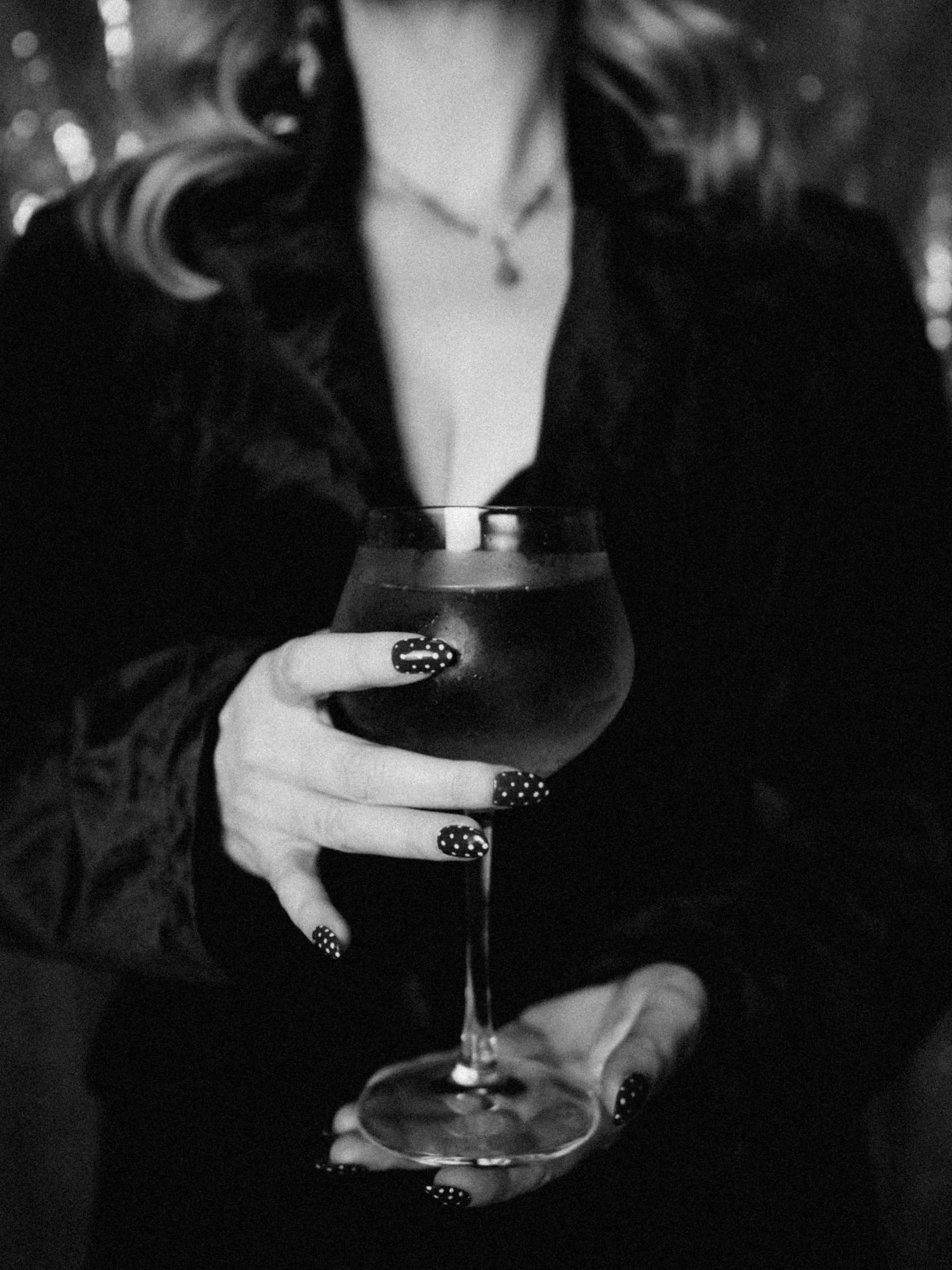 Woman with beautiful nails holding a glass of wine