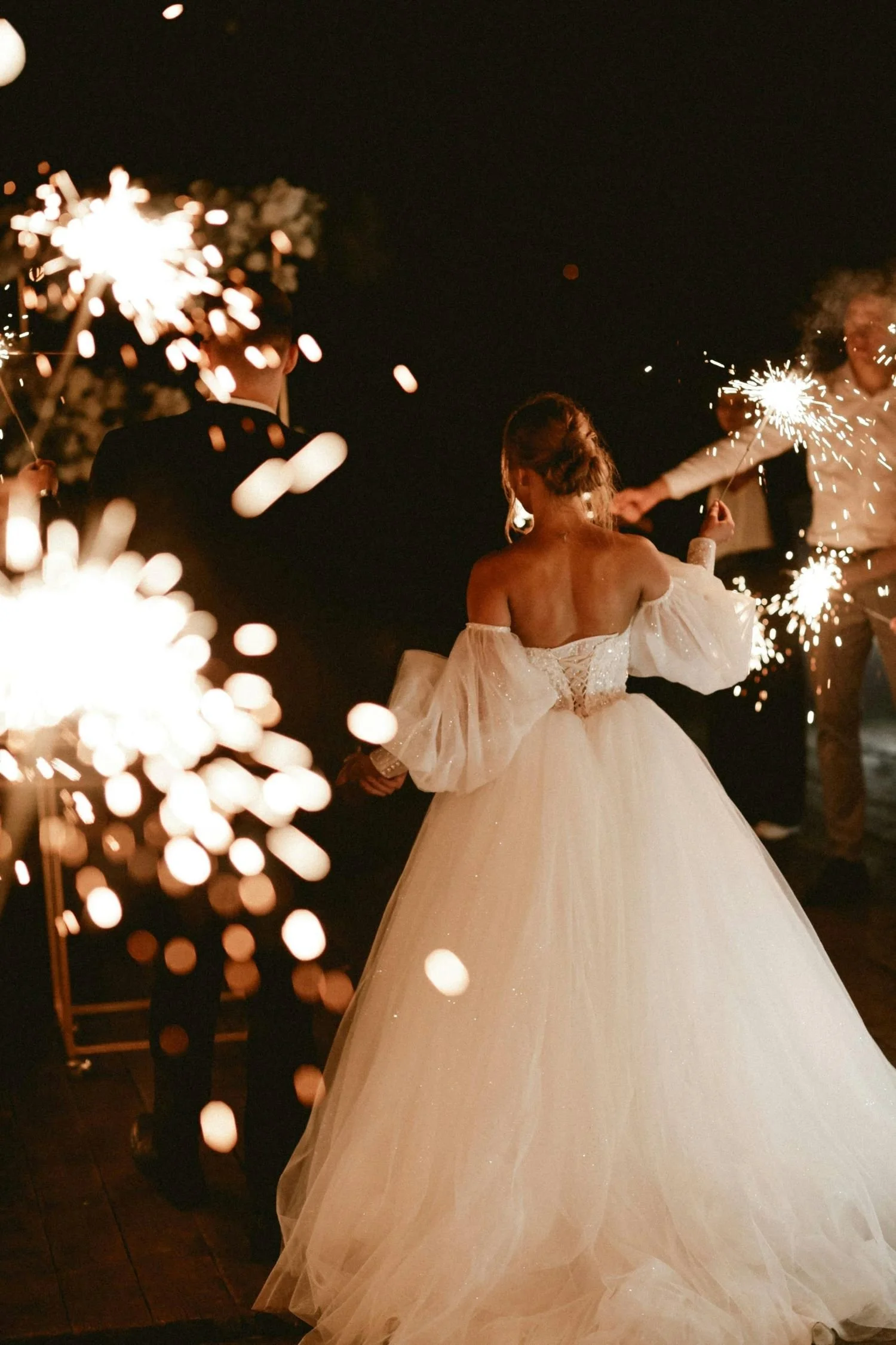 A bride celebrating with sparklers at her reception