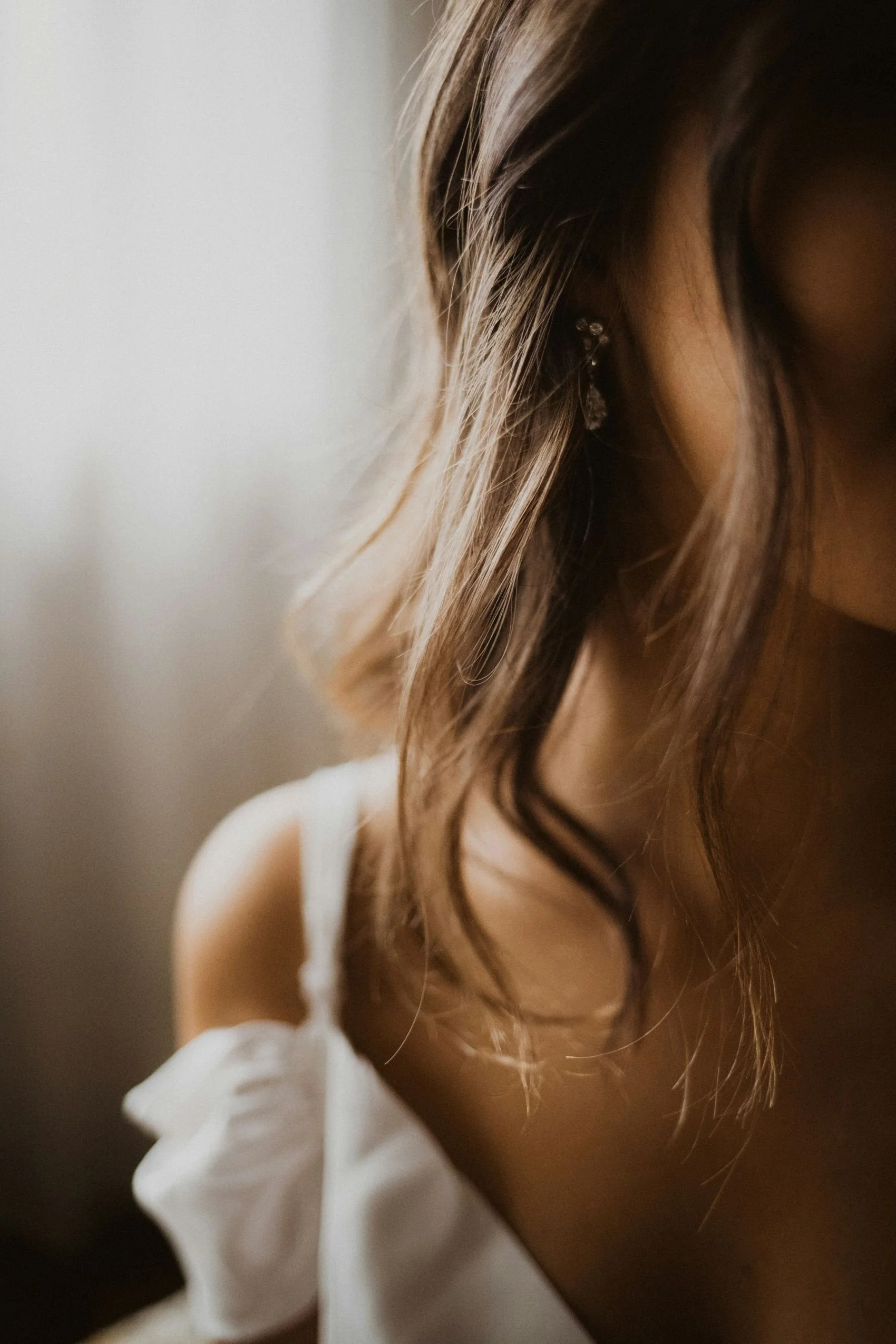 A bride with soft curls of hair falling on her shoulder