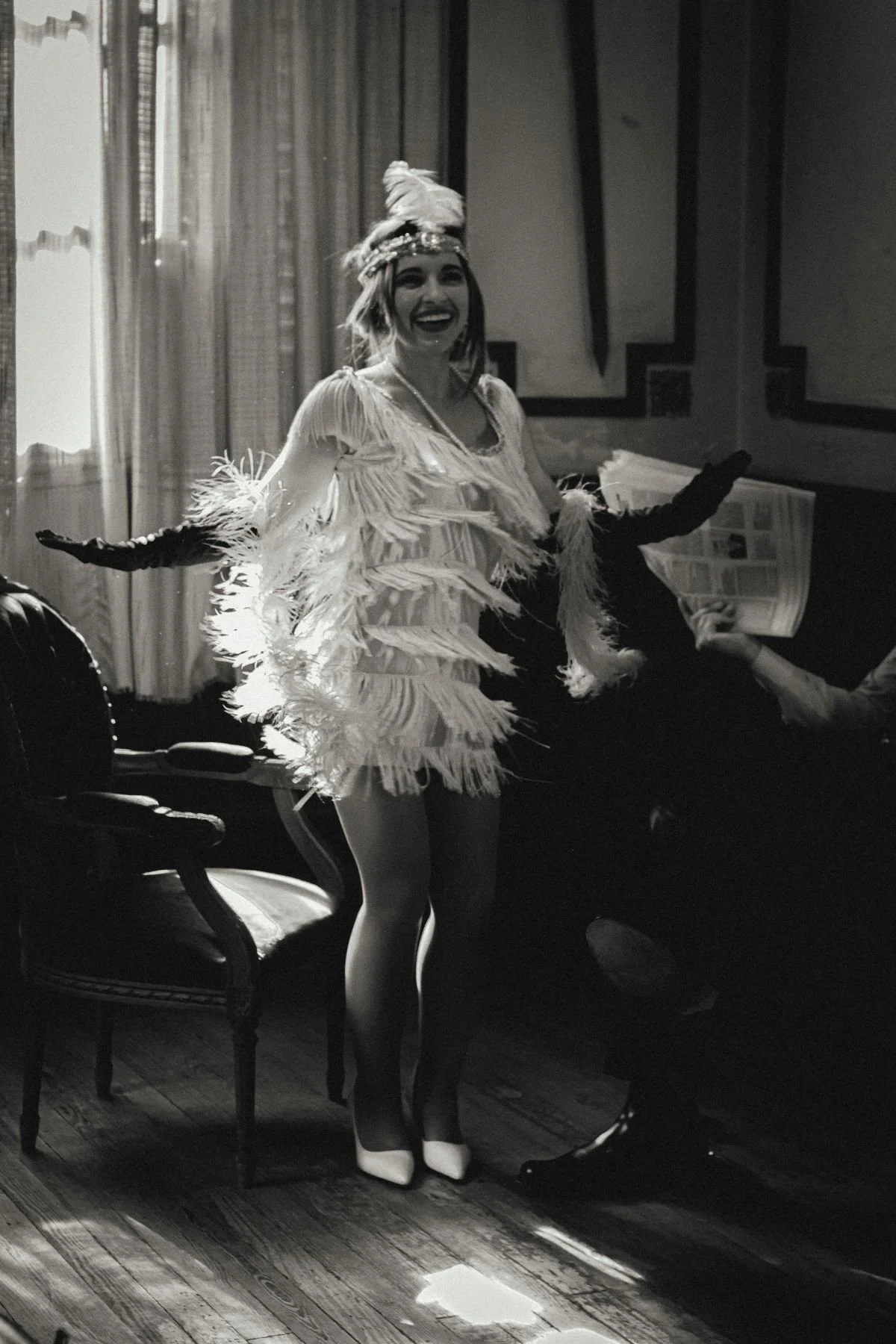 A woman dressed as a vintage flapper dancing in a beautiful room.