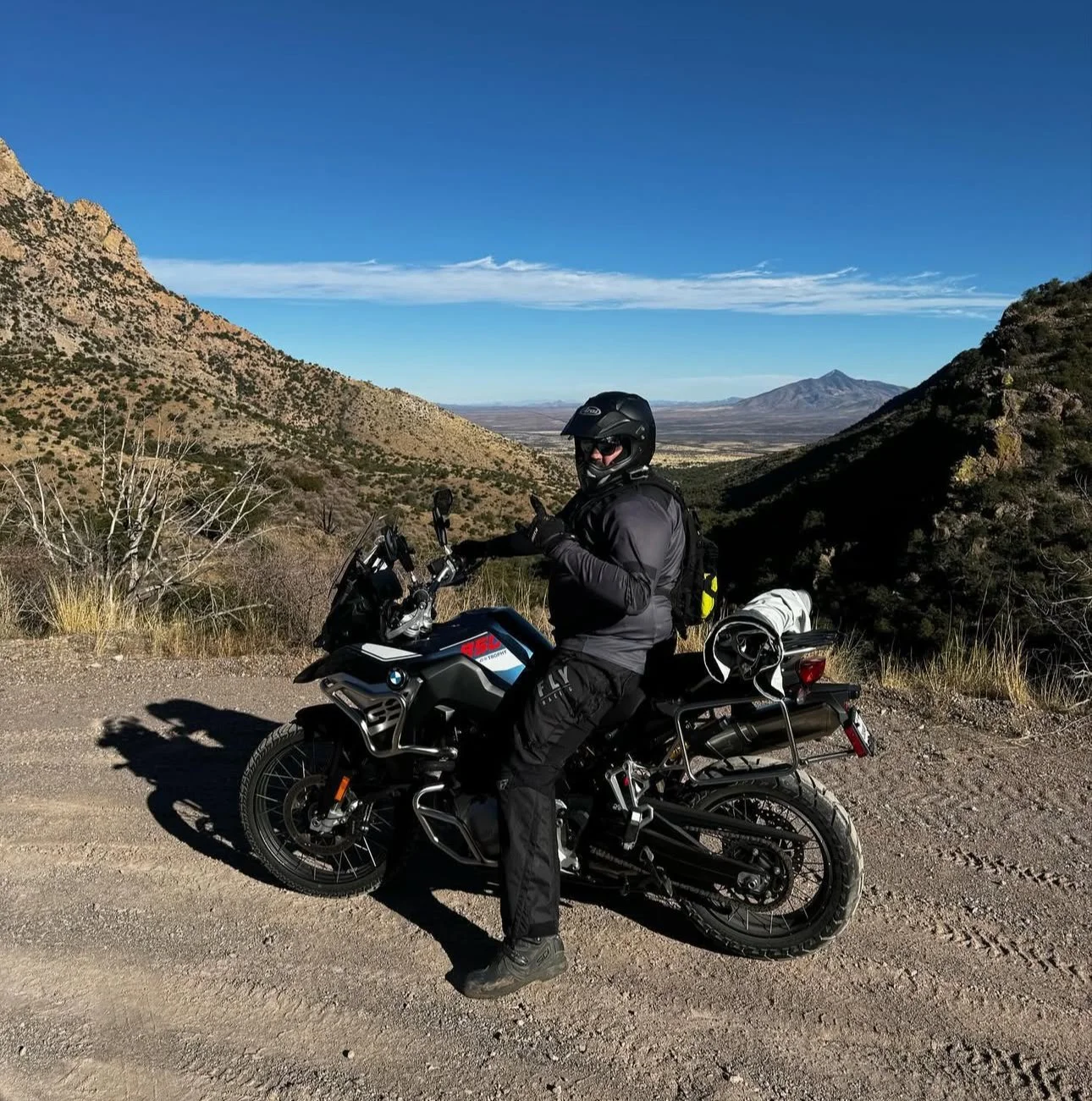 Man wearing a bucket hat and glasses, plaid shirt, close-up portrait in a garage.