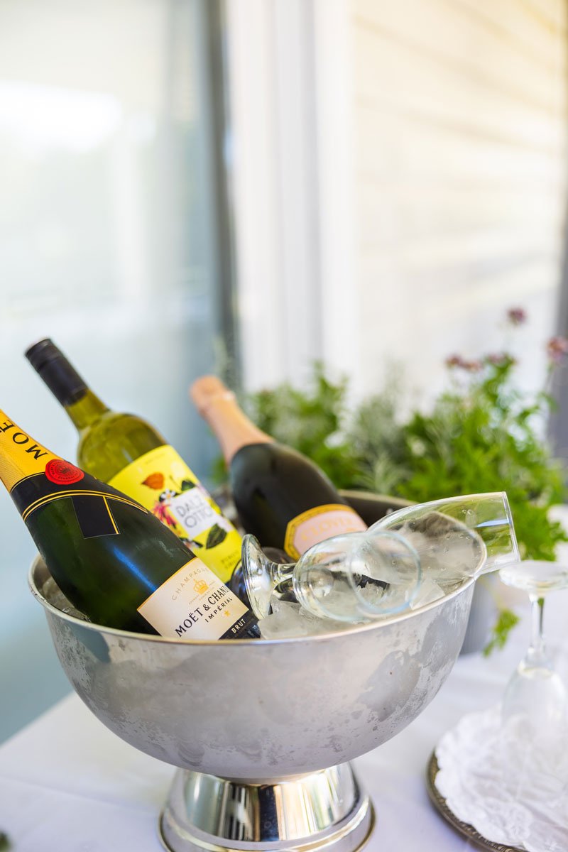 Champagne with wine glasses sitting in a wine bucket on a function table