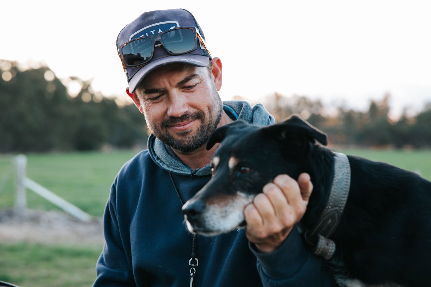 Man looking fondly at his old black and tan kelpie dog
