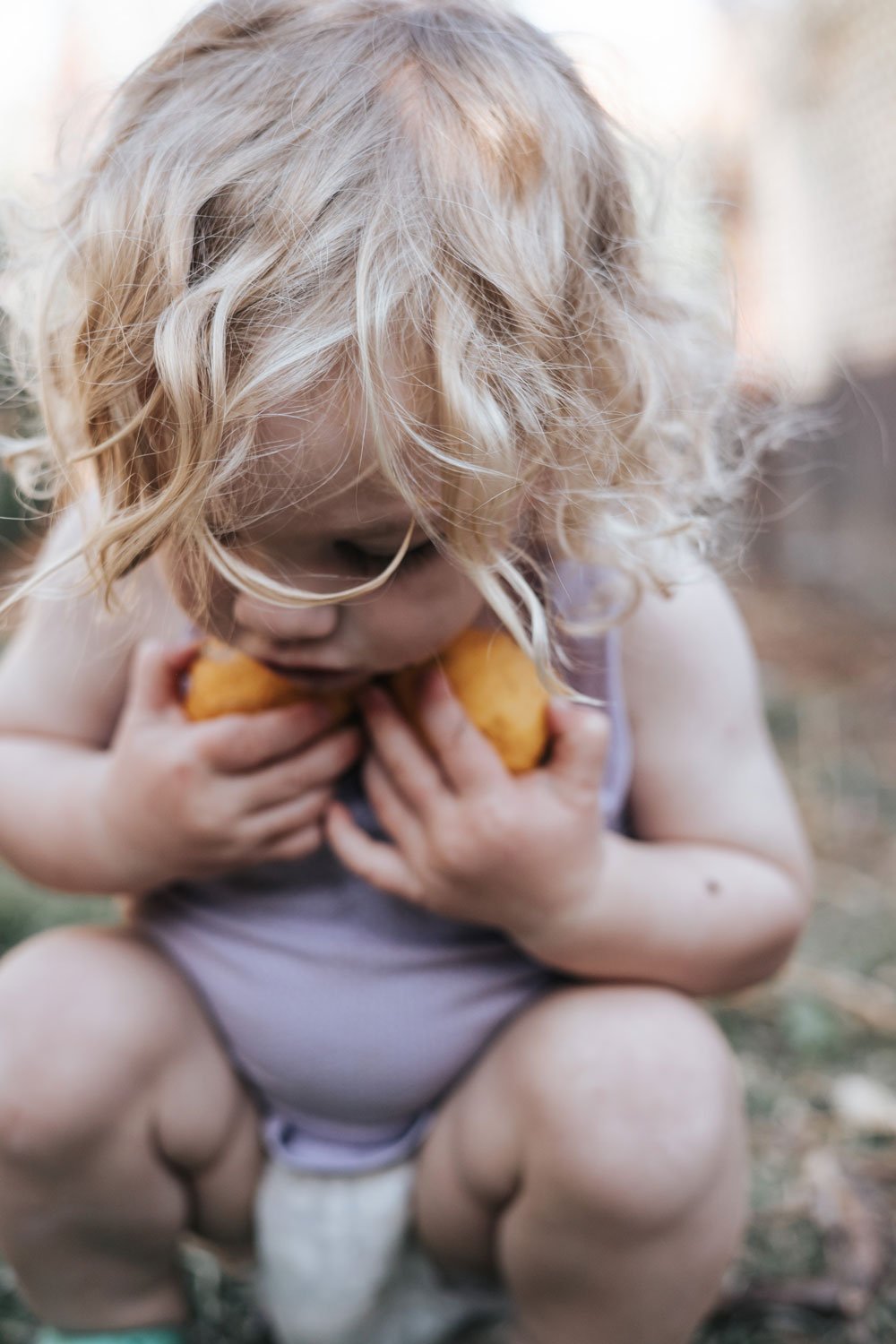 Young boy picking up lemons