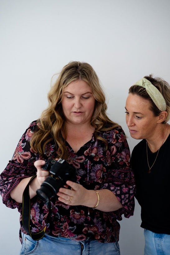 A photographer instructor teaching a studio how to use a camera