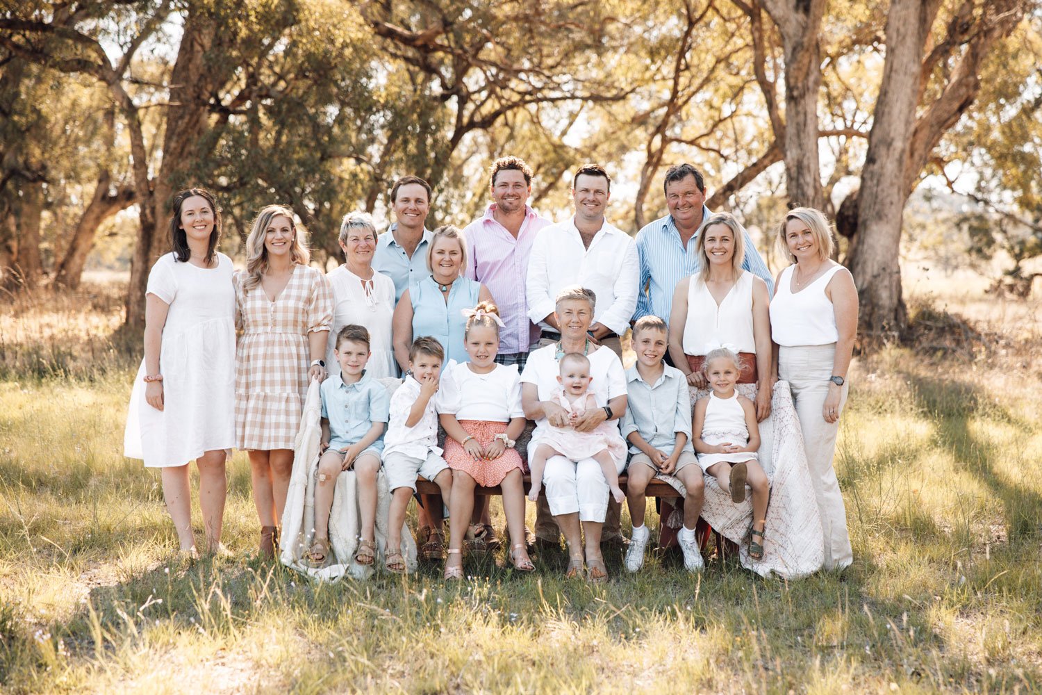 Big family with babies, young children, older children and grandparents smiling at the camera