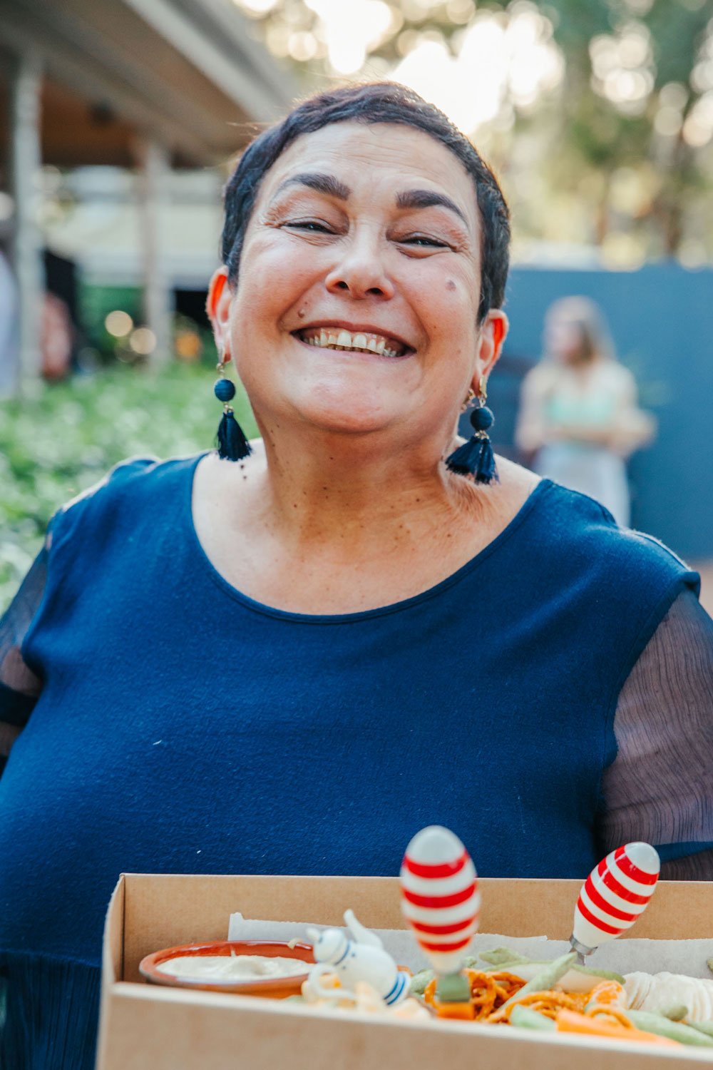 Catering woman smiling while holding a platter of delicious food