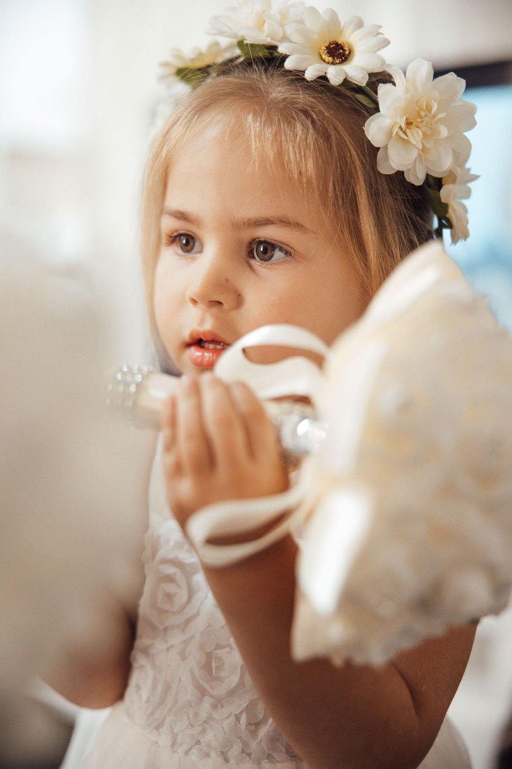 Close up of a flower girl holding bouquet near her face