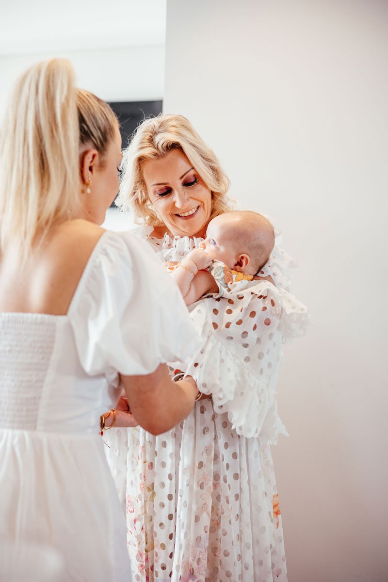 Two women holding and looking fondly at a young baby