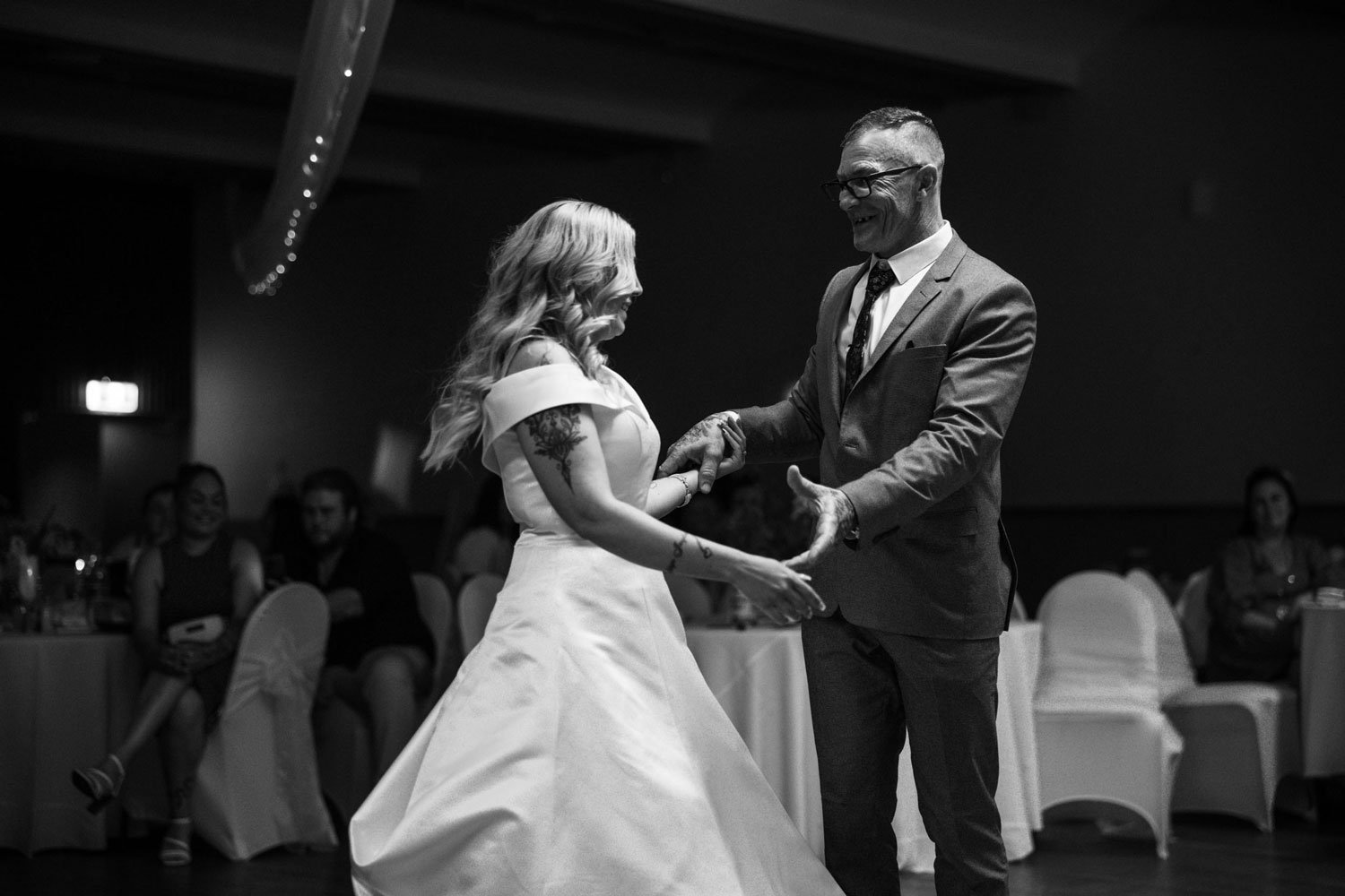 Black and white photo of bride and father of the bride dancing at the reception