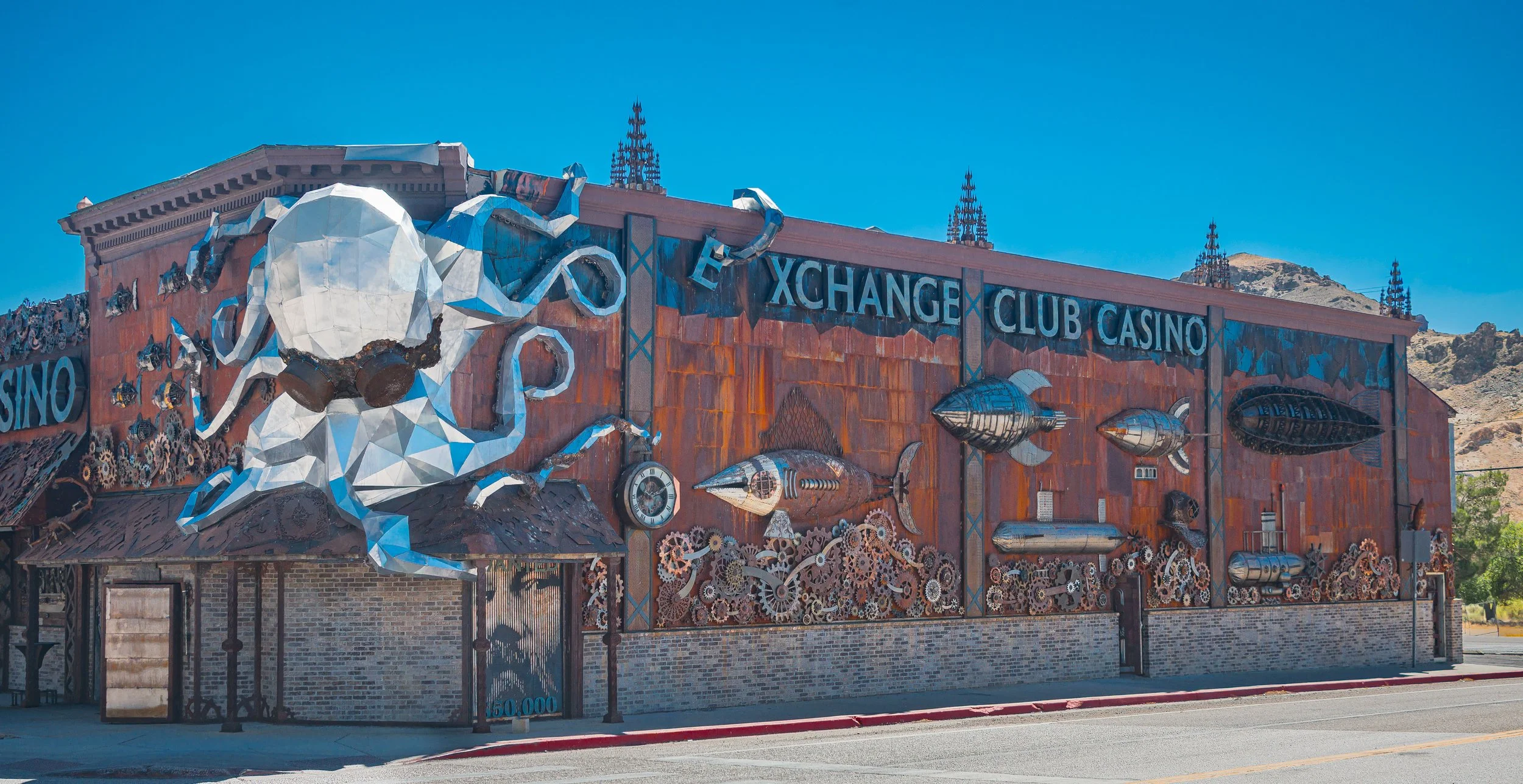 Metal dreams coil beneath the desert sun, an octopus of steel holding stories of how many trapped in its arms. Gears whisper of gamblers, wanderers, and time frozen or lost; a steampunk sentinel watching the wide Nevada sky.