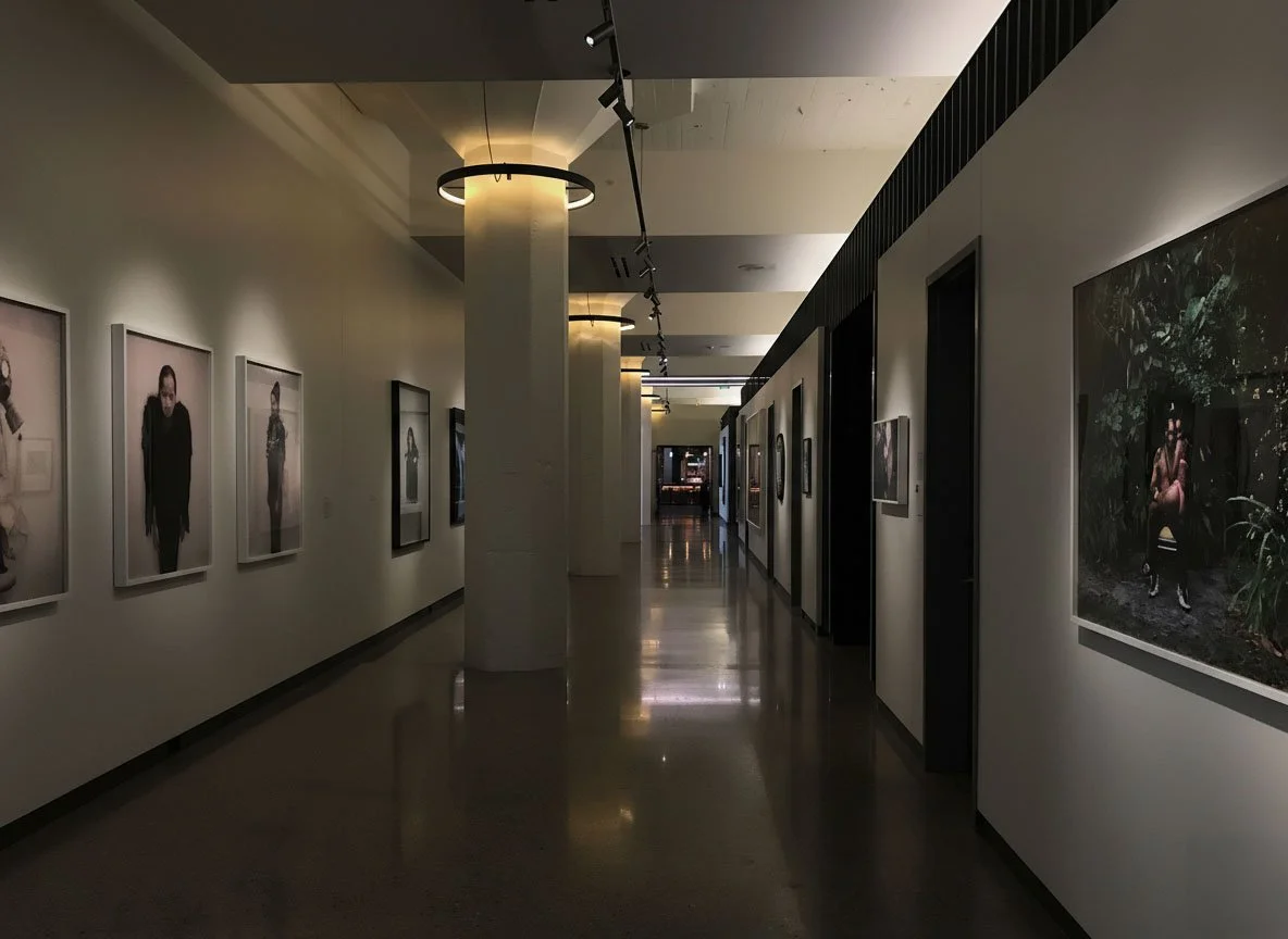 21c Museum Hotel corridor with architectural lighting and track lighting illuminating the contemporary artwork.