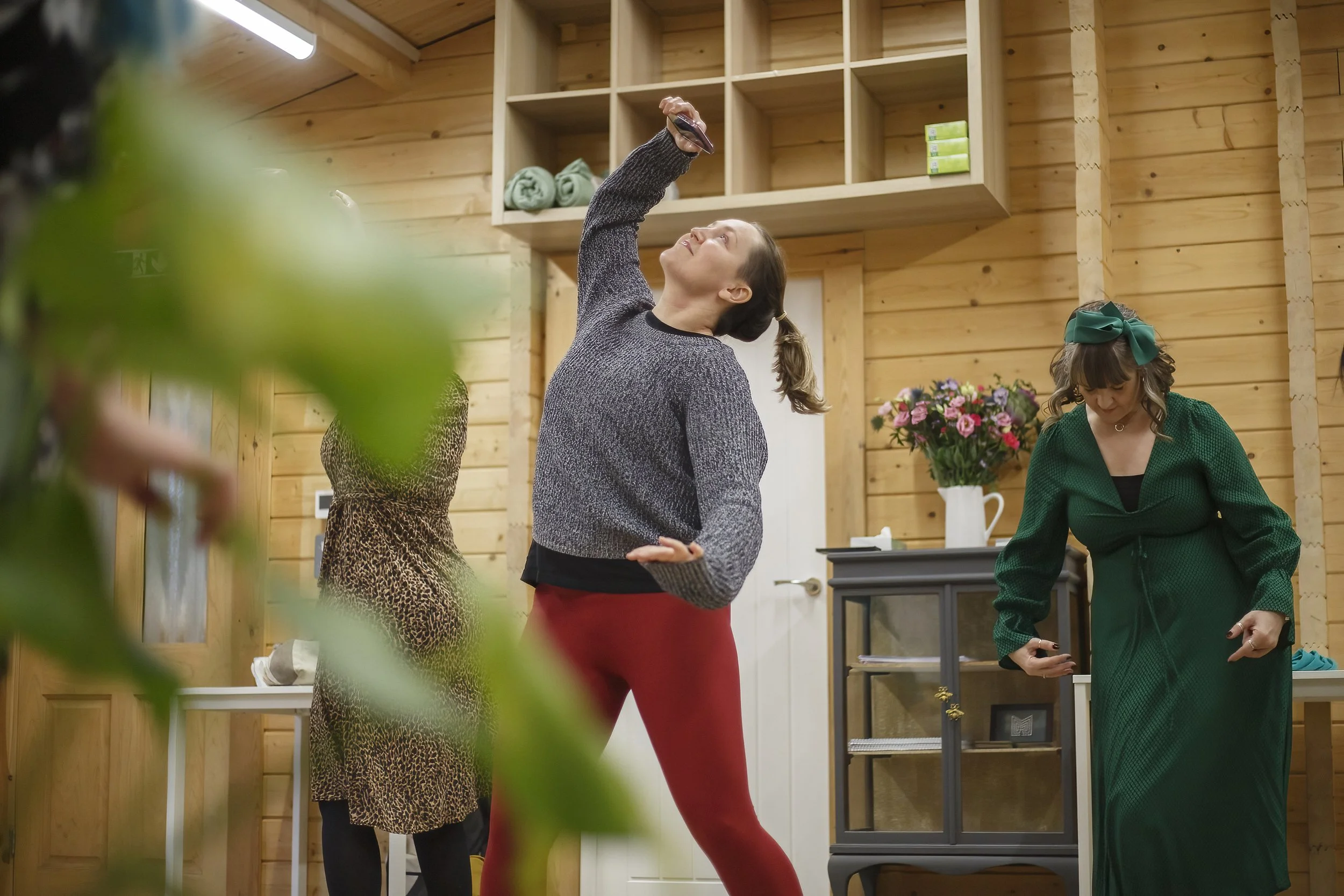 Sarah, a white woman with brunette mid length hair smiling in a somatic movement session looking free and happy