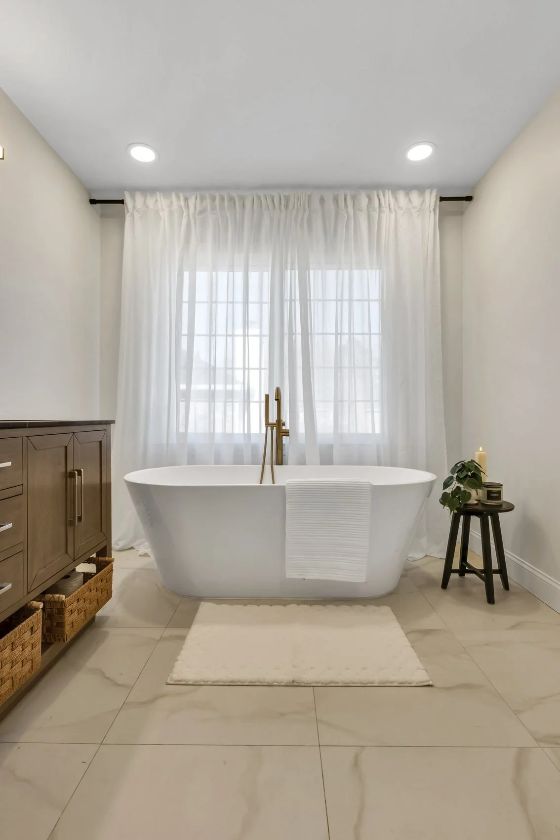 Remodelled primary bathroom vanity with black stone countertop and brass fixtures