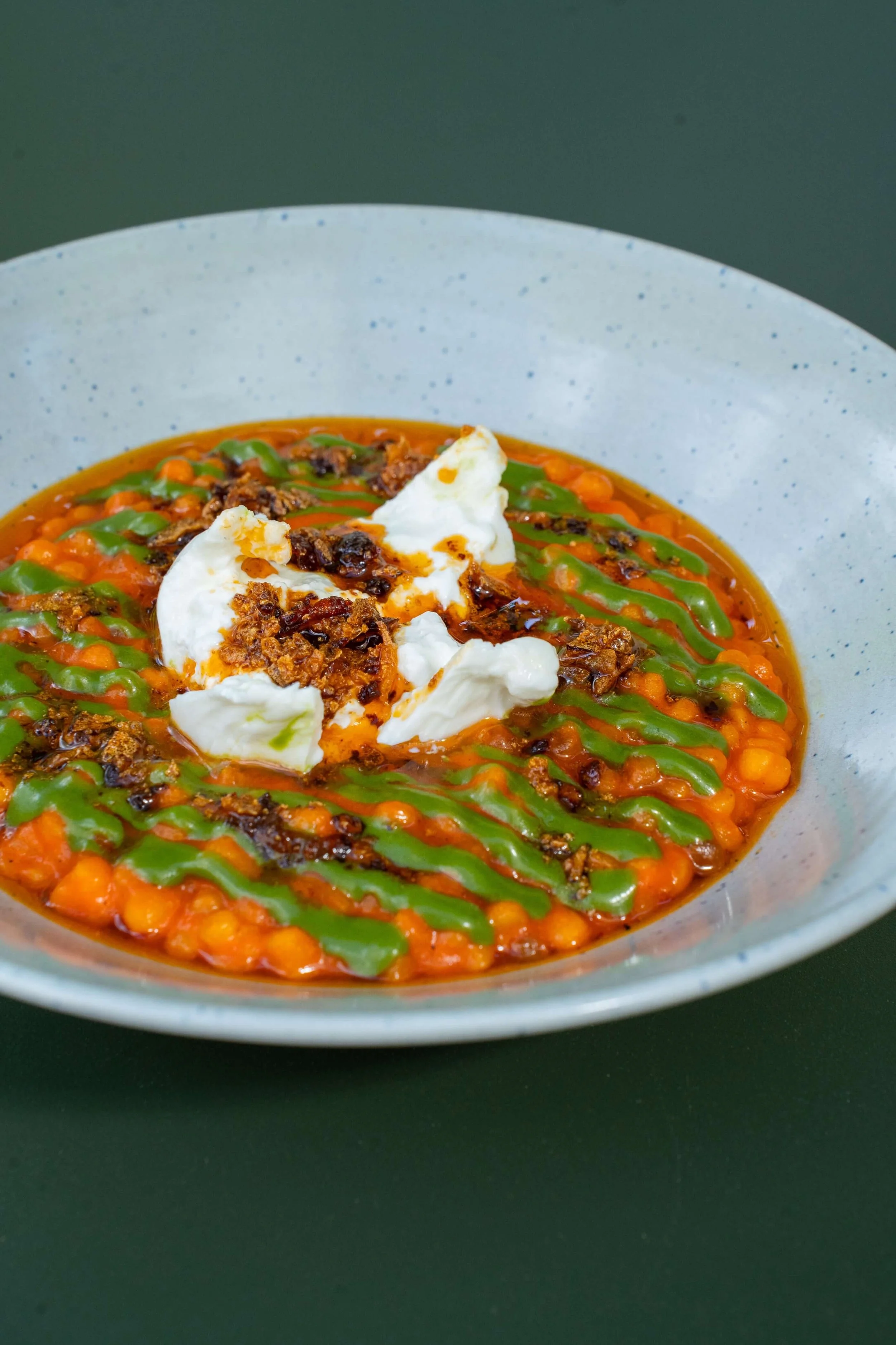 Fregola sarda with roasted pepper sauce, burrata and chili crunch at in Zürich, switzerland