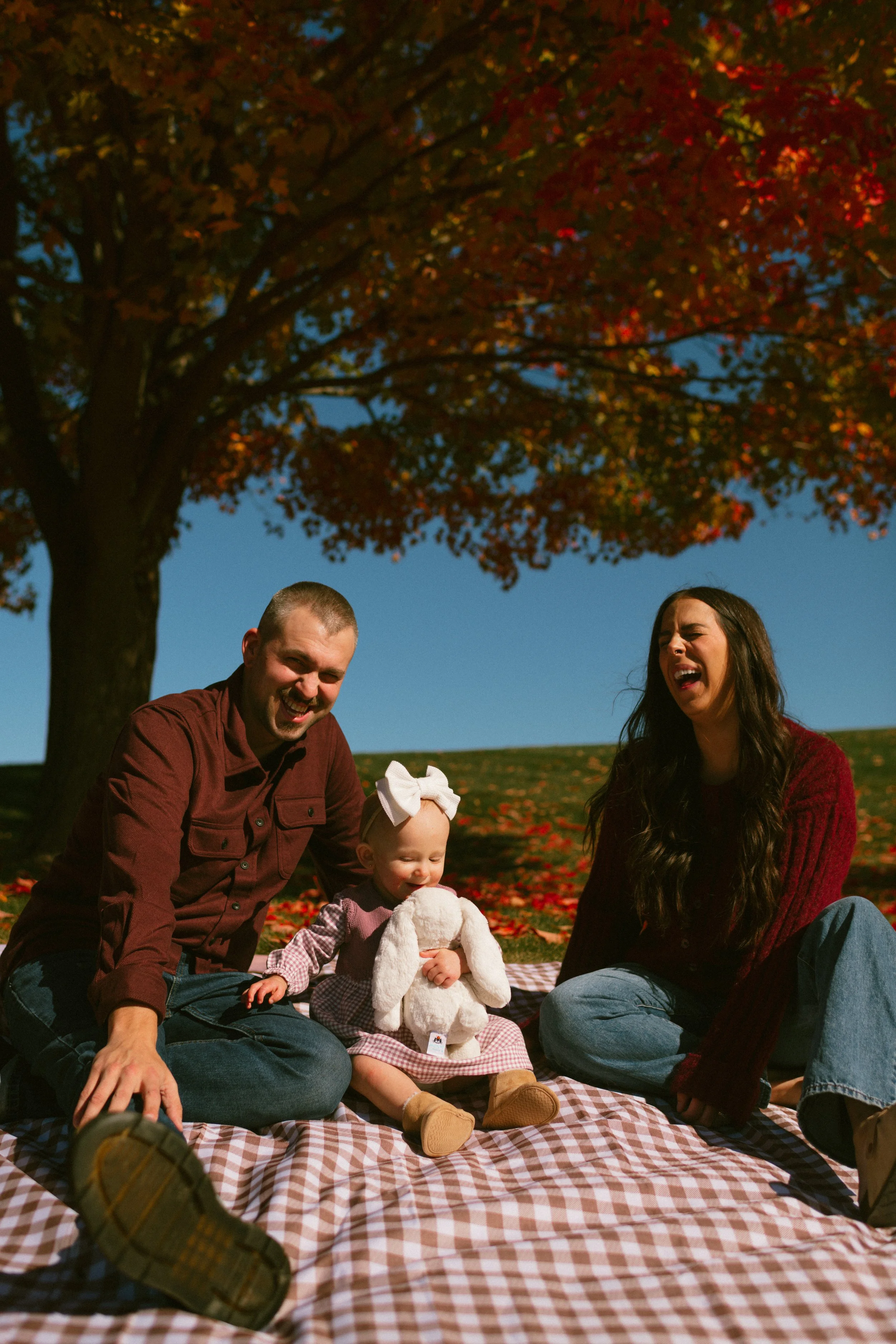 Mom dad and baby, blue sky, picnic, mom laughing