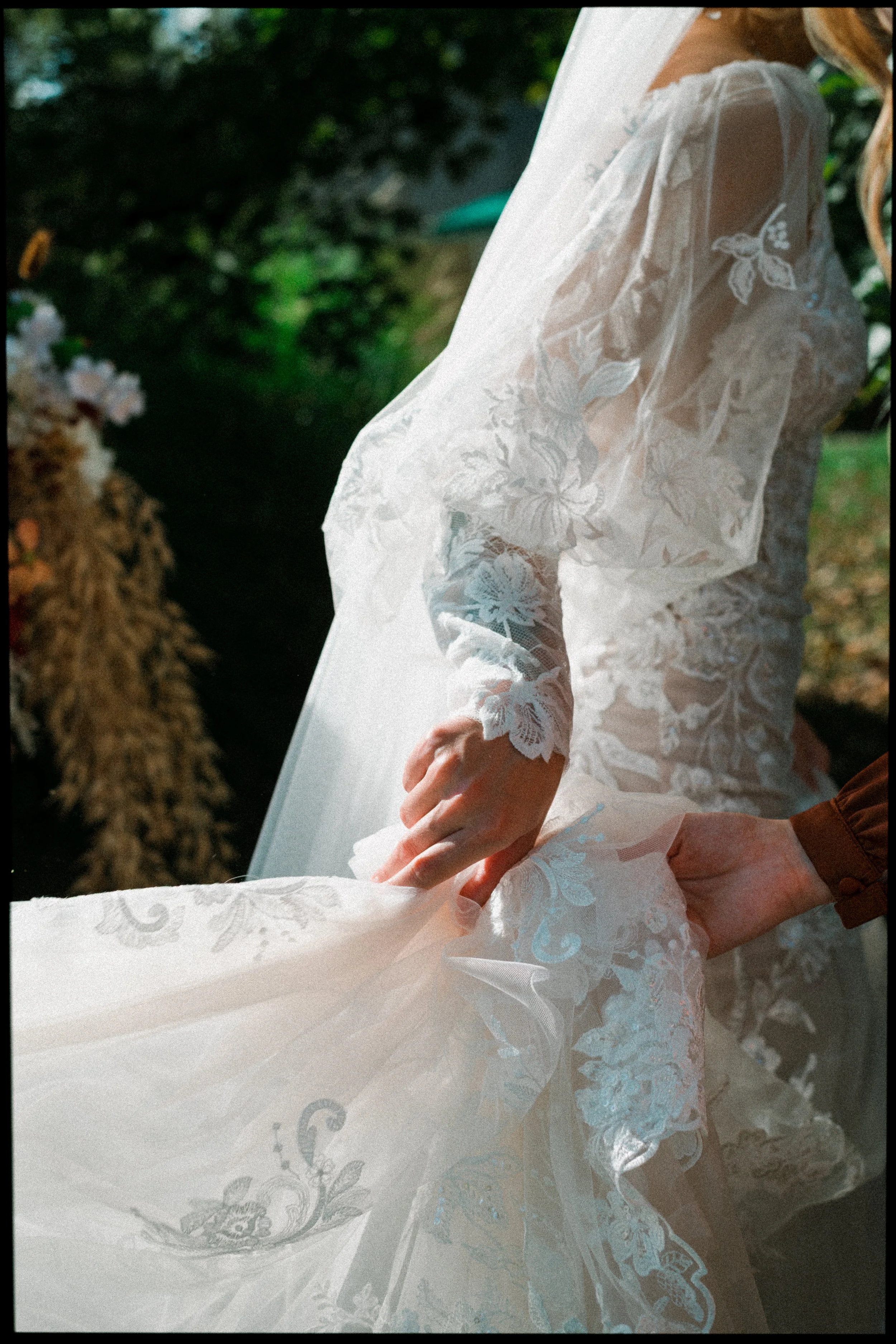 photo of bride and bridesmaid helping lift her dress