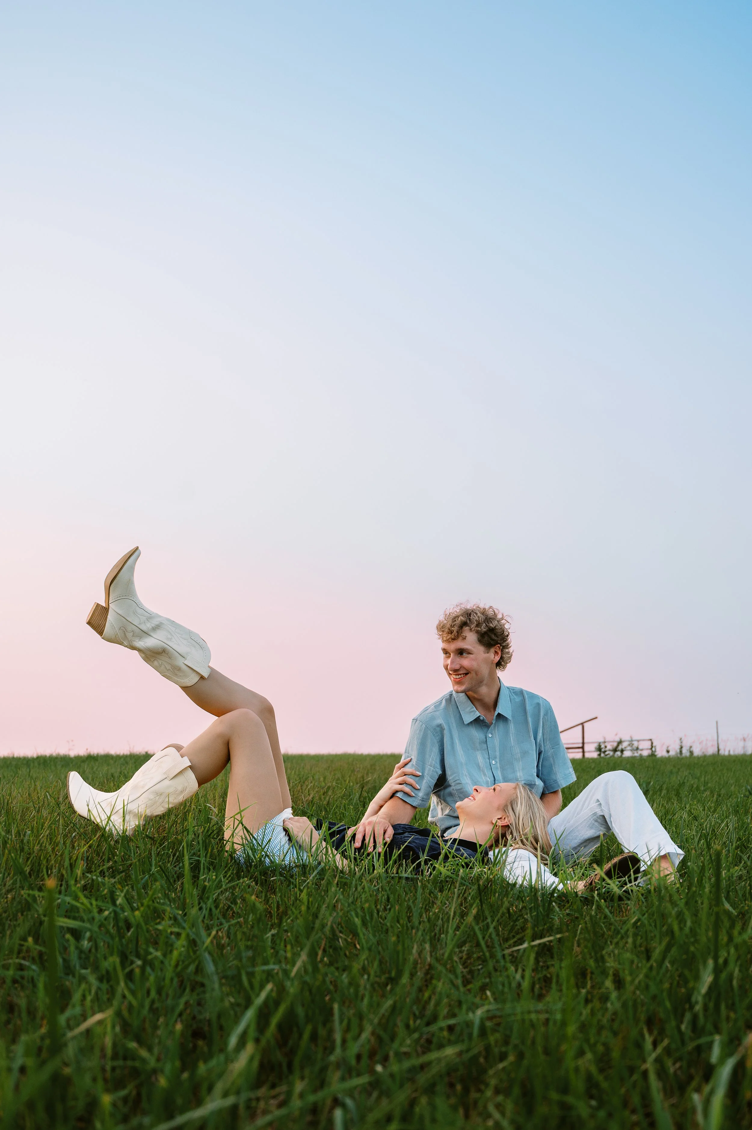 Playful couple relaxing in a field during a Michigan couple session