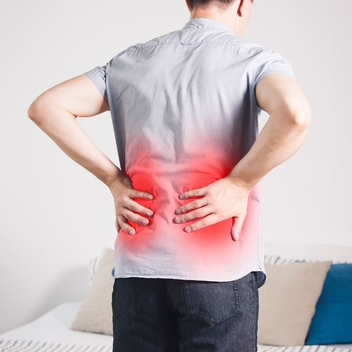 Man showing lower back pain and sciatica symptoms; relevant to lumbar pain conditions treated with Ayurvedic oil massage and physiotherapy at Kerala Ayurveda Clinic in Leicester.
