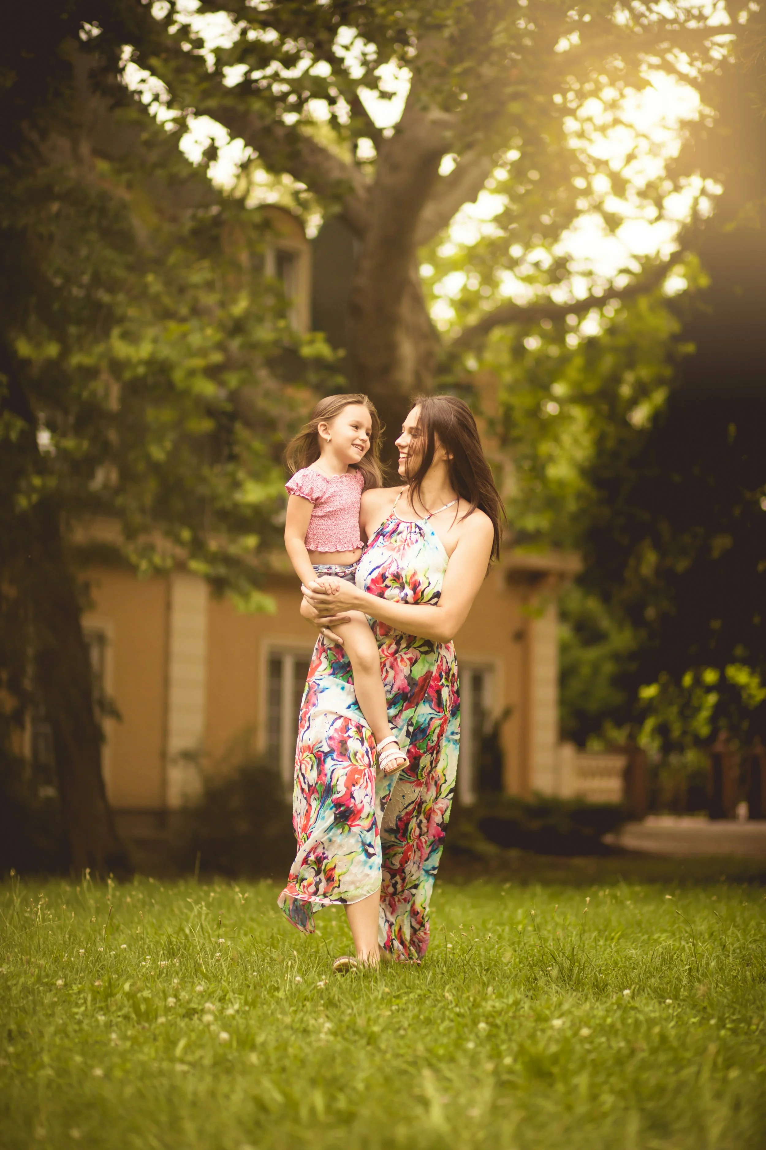 Woman walking outside while holding her toddler daughter.