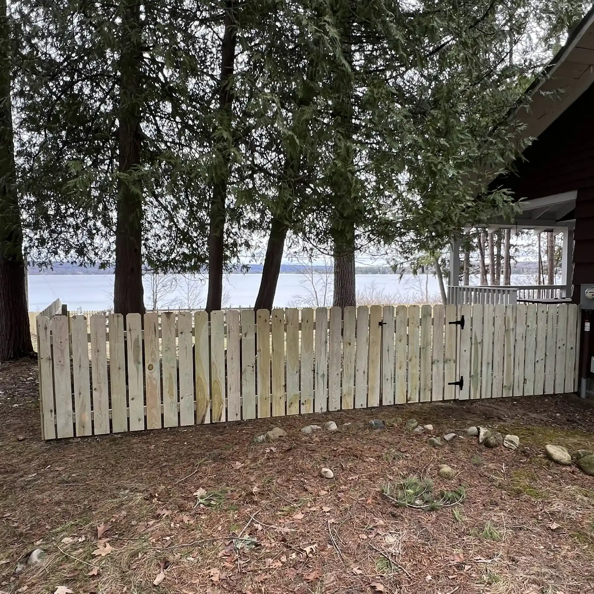 wood picket privacy fence with lake in background