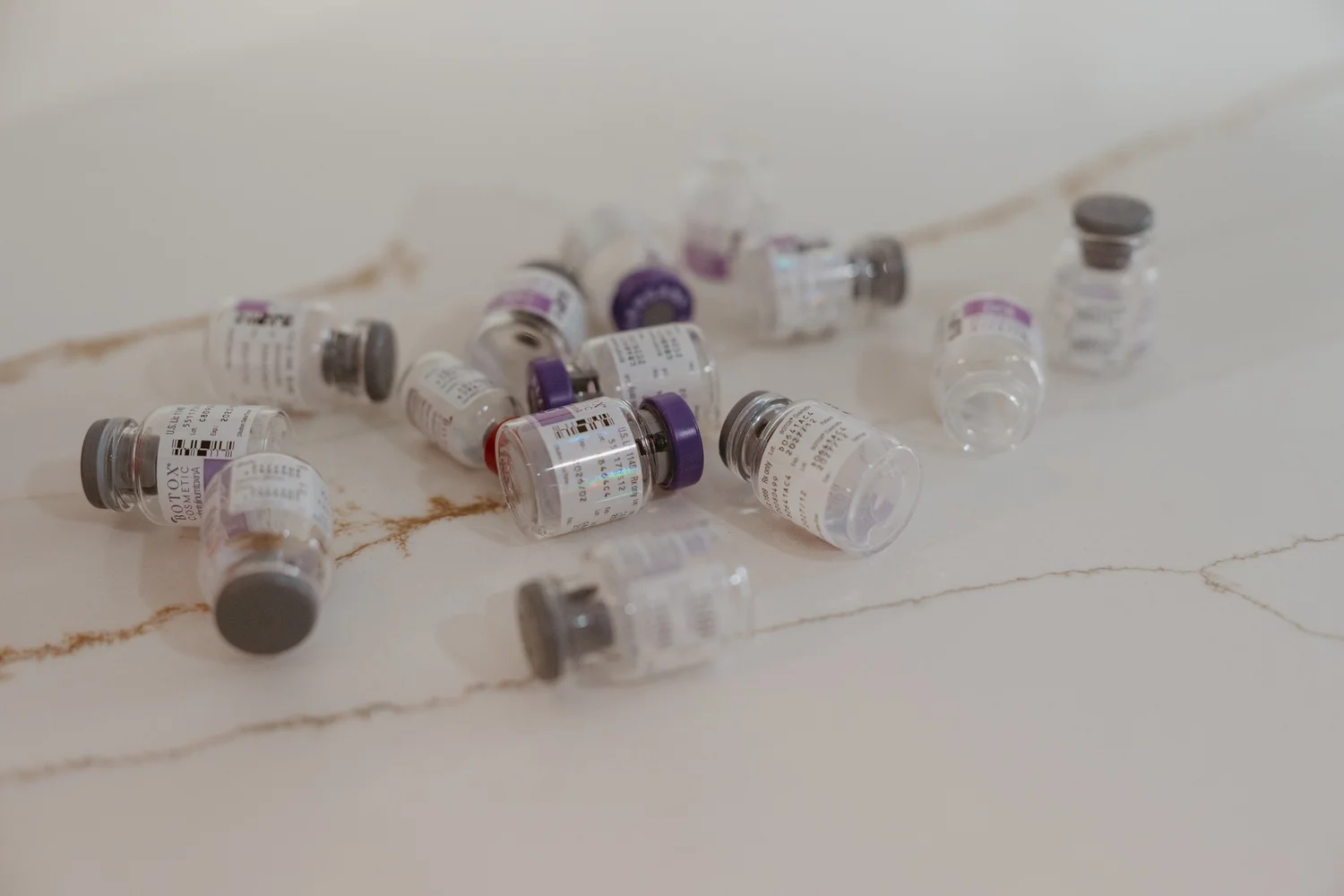 Botox vials scattered on a marble surface