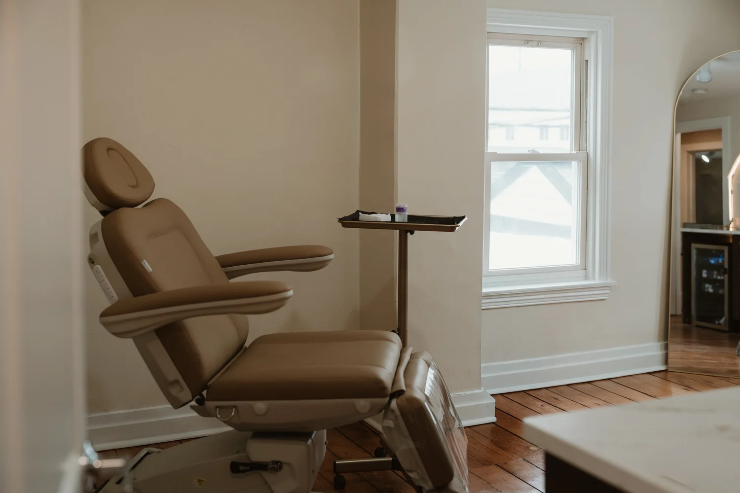 Bright treatment room with a cream treatment chair at CoCo Aesthetic