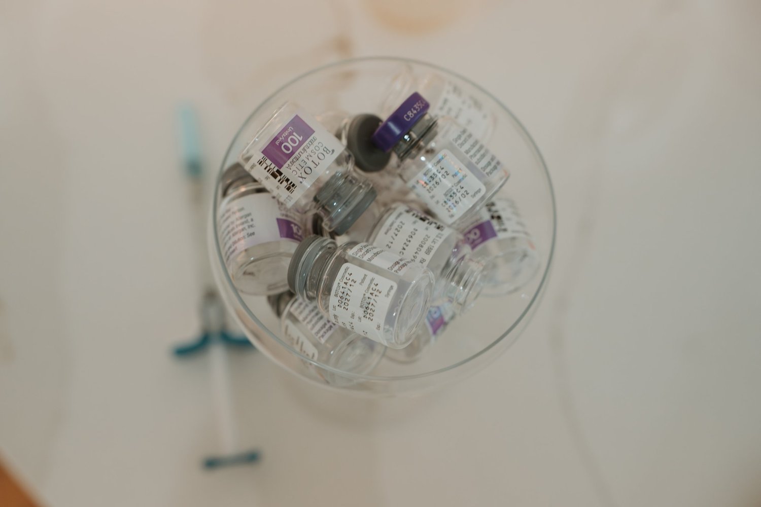 Neuromodulator vials gathered in a glass dish