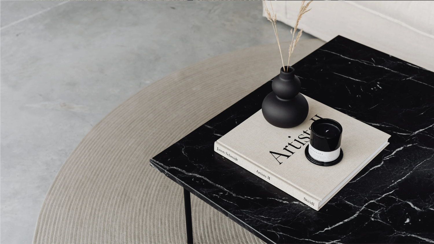 Black marble side table with a candle and books in the CoCo lounge