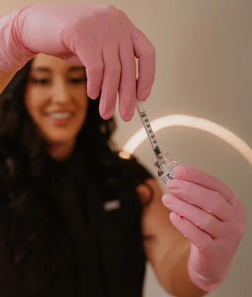 CoCo Aesthetic injector smiling while preparing a syringe in the Malvern studio — view more on Instagram