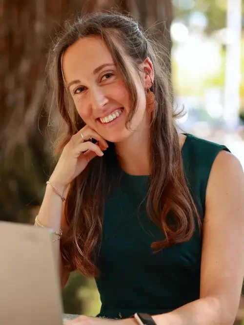Cassandra Amantite has brown hair, a green top, and is smiling.