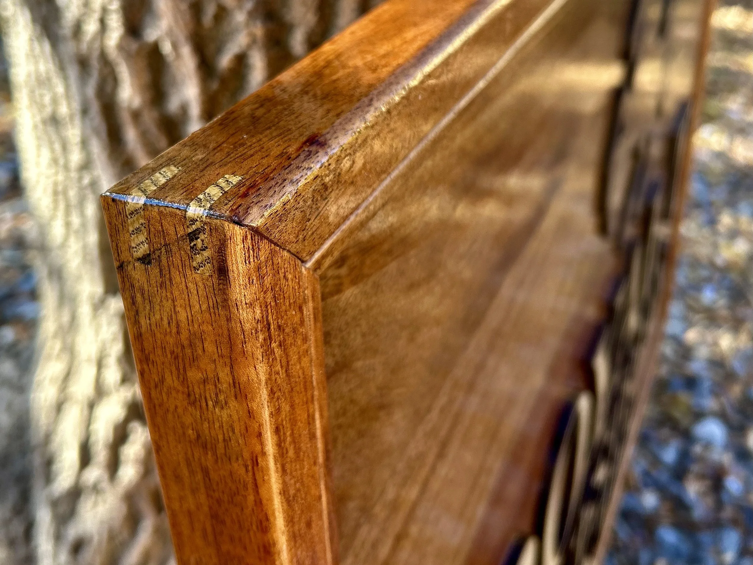 A close up shot of mitered corners on a floating frame. Mahogany Wood and Oak Splines