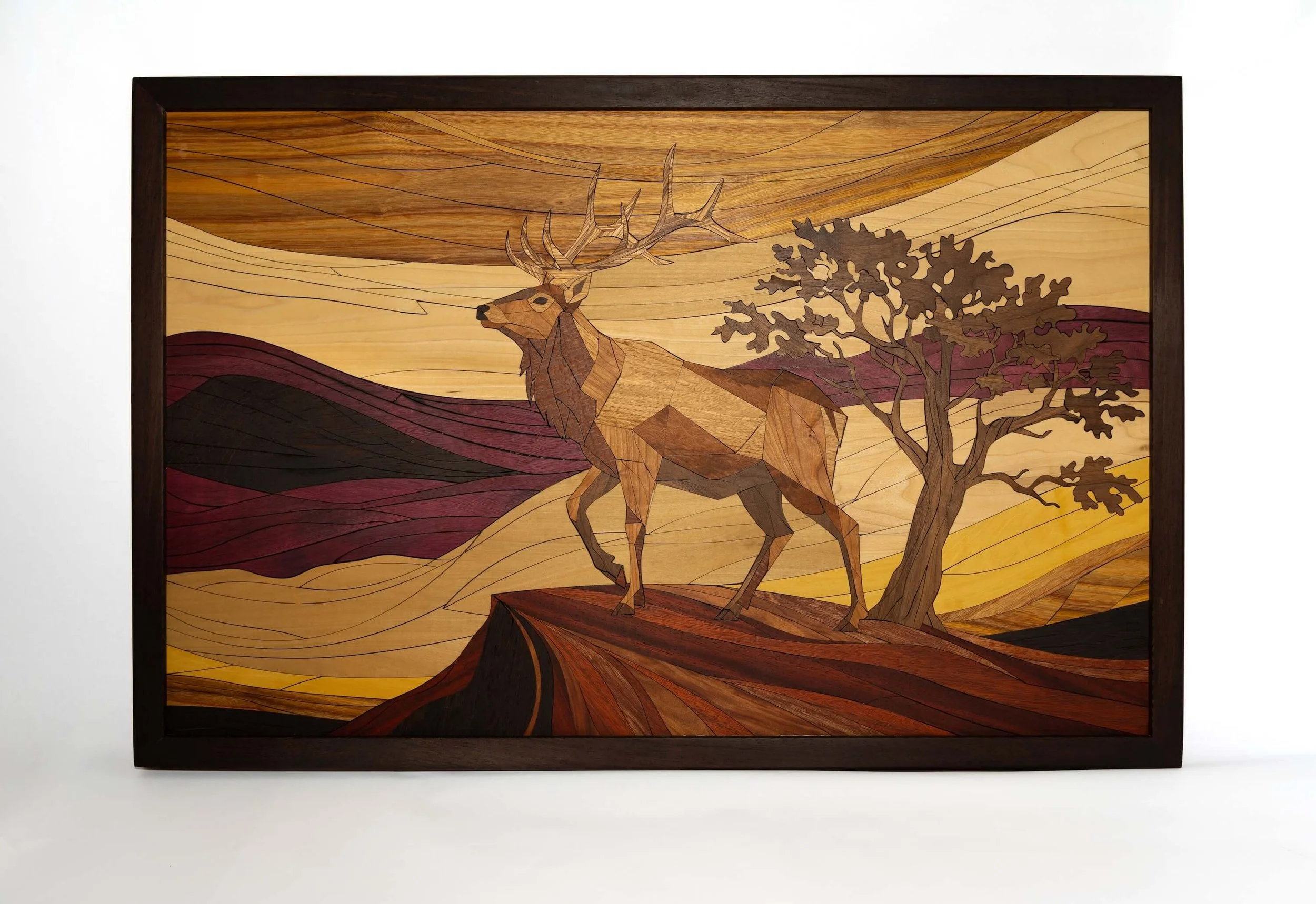 Wooden art piece depicting a stag beside a tree, with abstract landscape in the background.