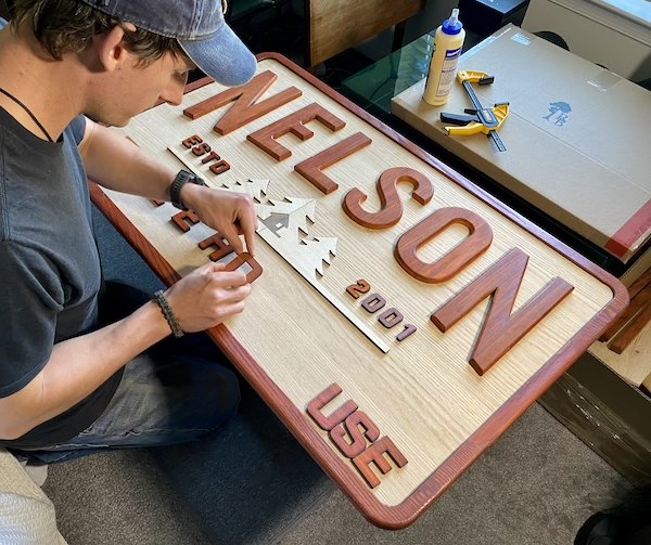 Handbuilding a custom wood sign. This sign says "Nelson Treehouse" and is for a treehouse company.
