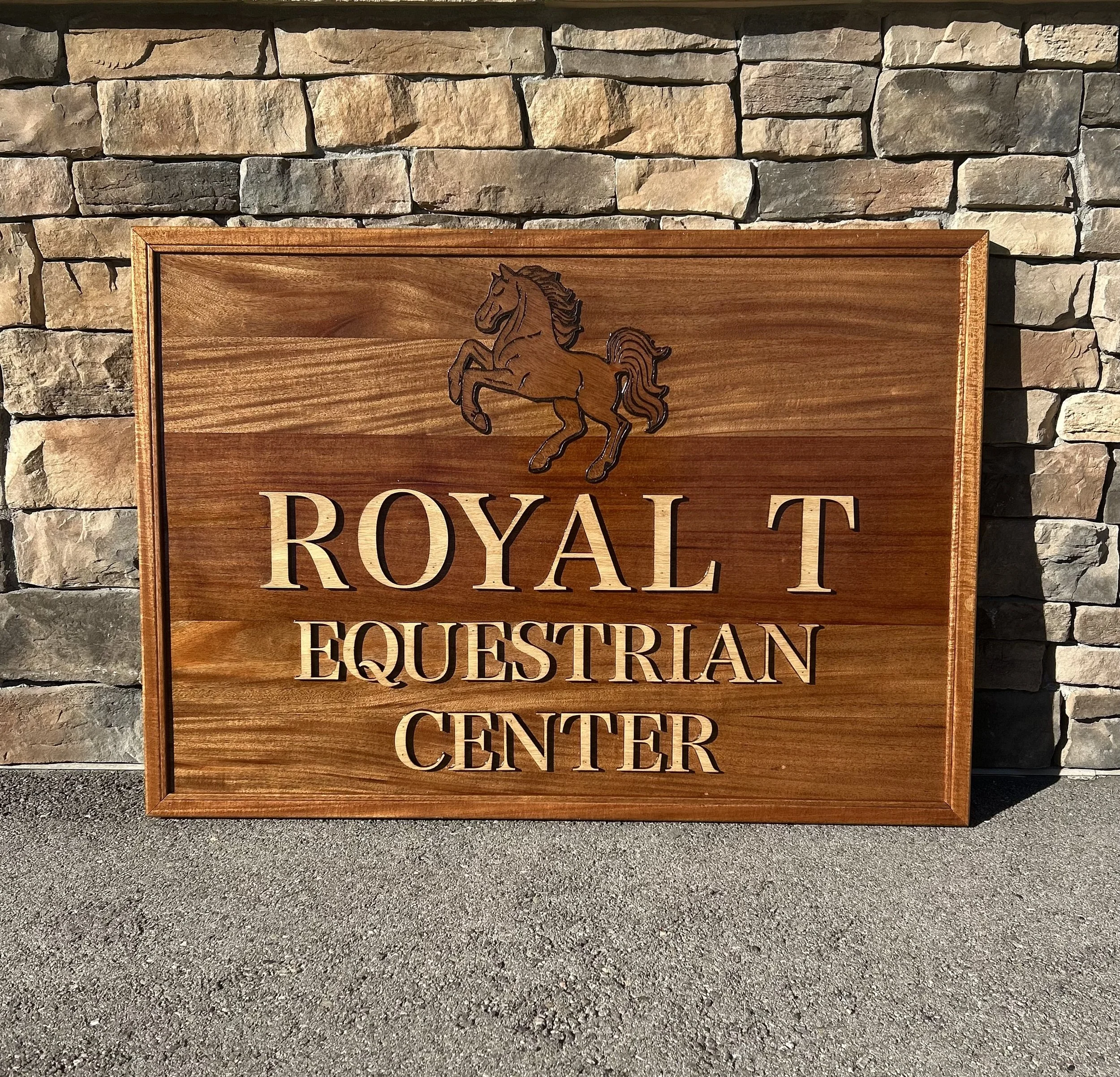 A mahogany outdoor wood sign for a Equestrian Center with a mitered floating frame. Custom wood sign.