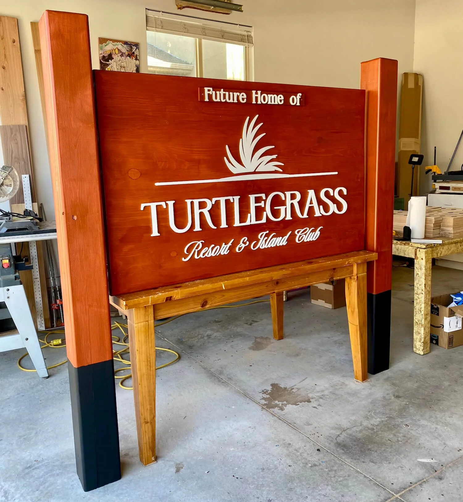 Wooden sign with white lettering that reads 'Future Home of Turtlegass Resort & Island Club'.