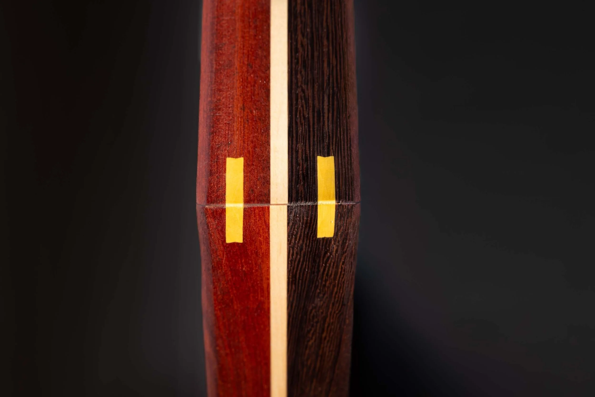 Close-up of a wooden object with vertical stripes of different colors and textures.