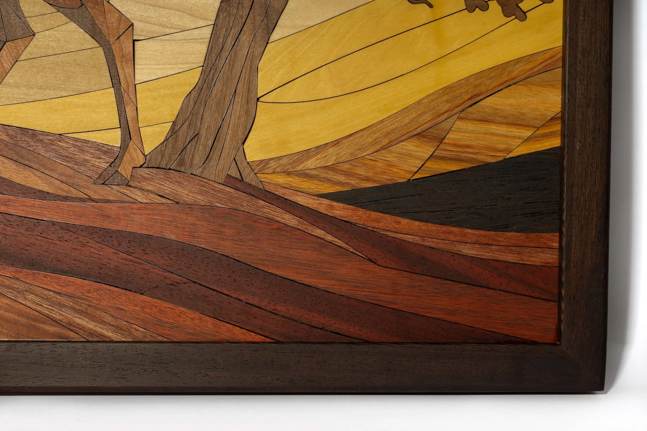 Close-up of a wooden artwork with various shades and grain patterns, shaped into abstract, flowing forms.