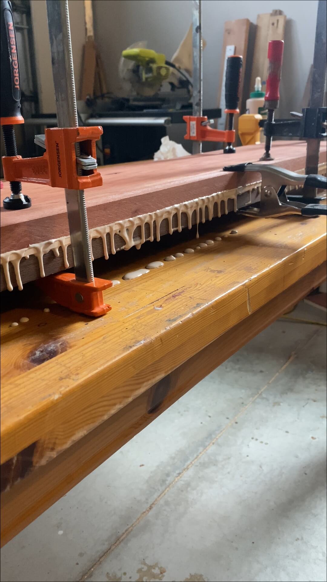Woodworking workshop with clamps securing a piece of wood and glue designed for woodworking.