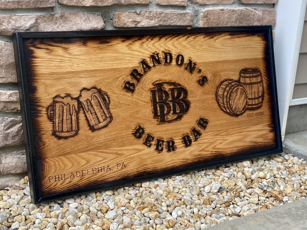 Wooden sign for Brandon's Beer Bar with illustrations of beer mugs and barrels, located in Philadelphia, PA.