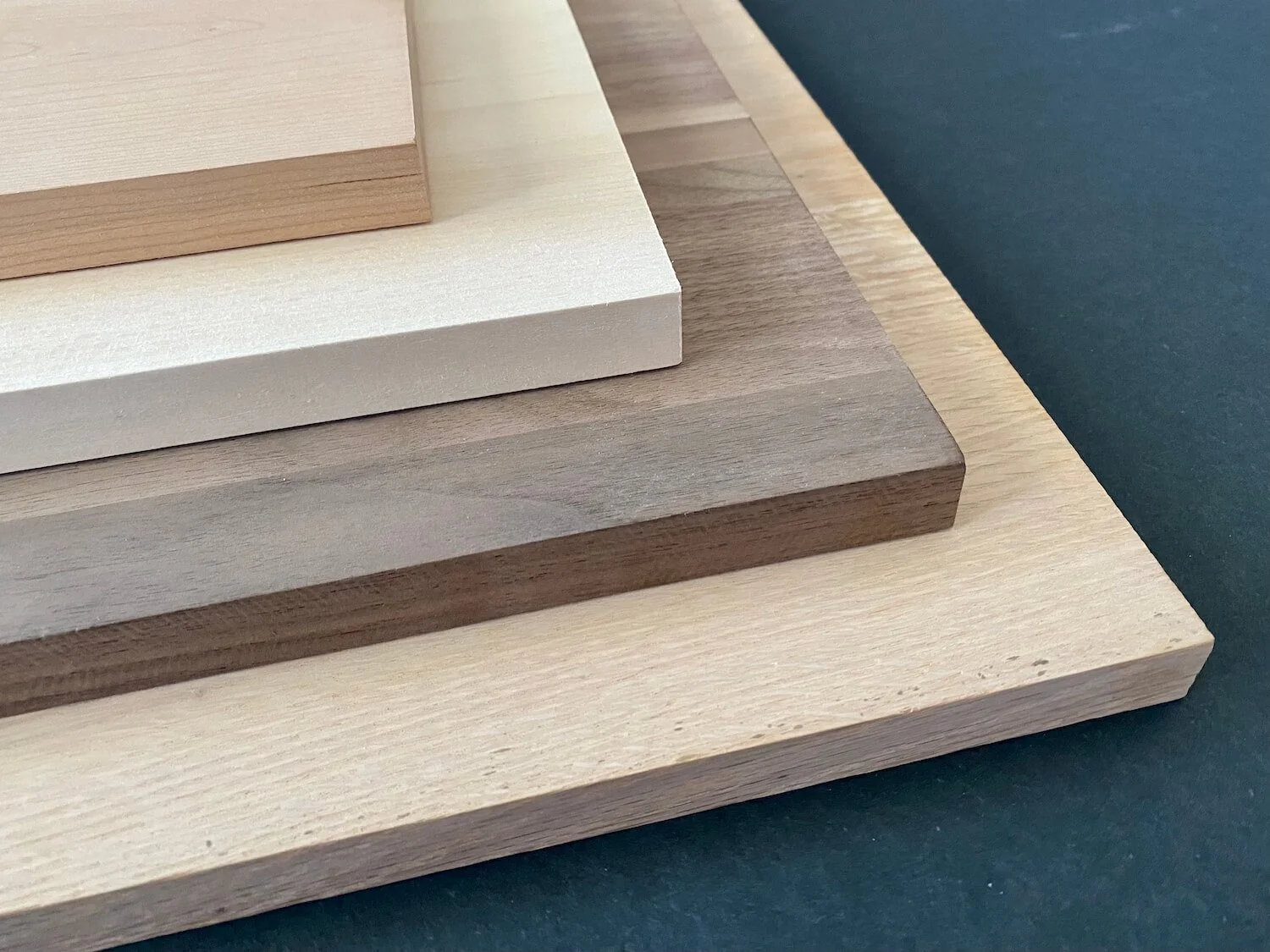 Four species of wood stacked on top of each other, showing the best types of wood to use for wood burning.