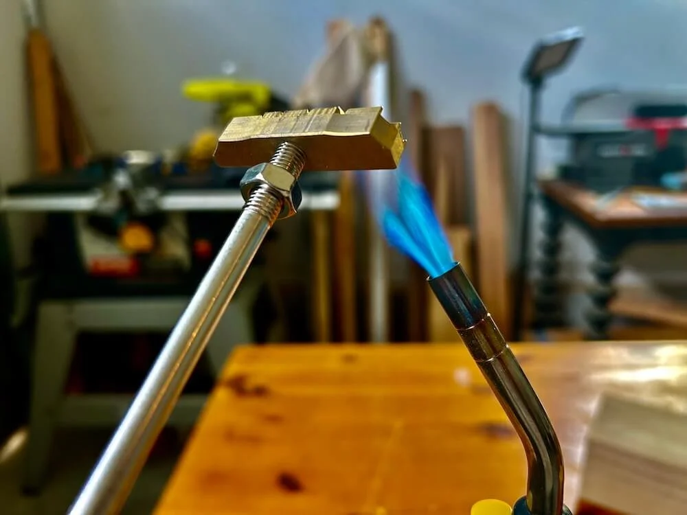 A blowtorch heating the tip of a custom branding iron