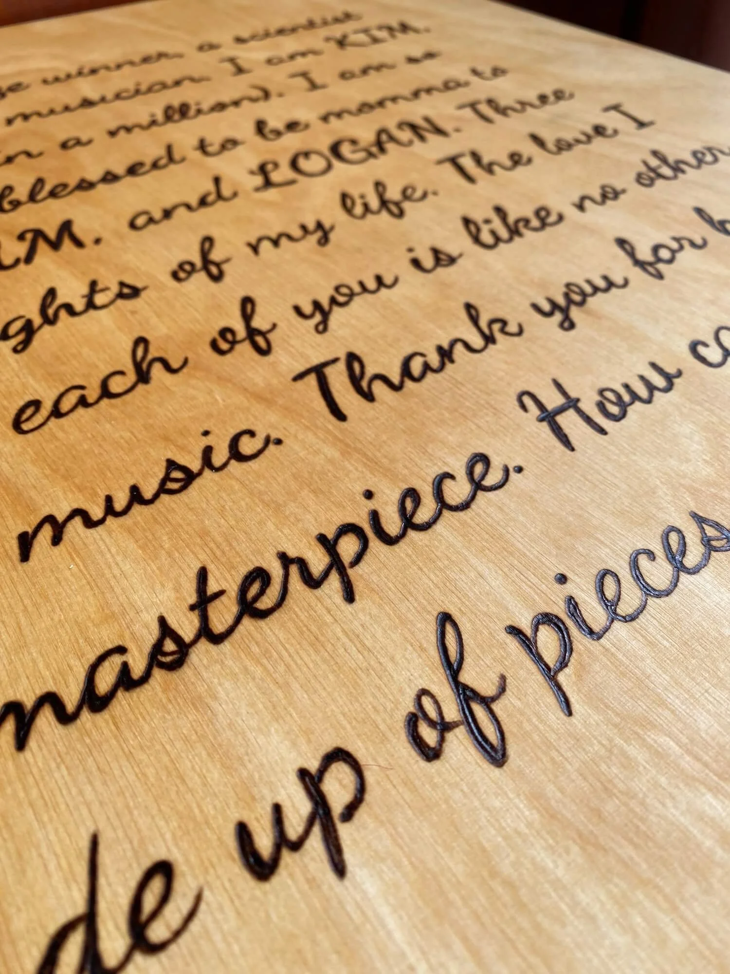 cursive text burnt into pine wood, showing how pyrography can create intricate detailing with wood burning