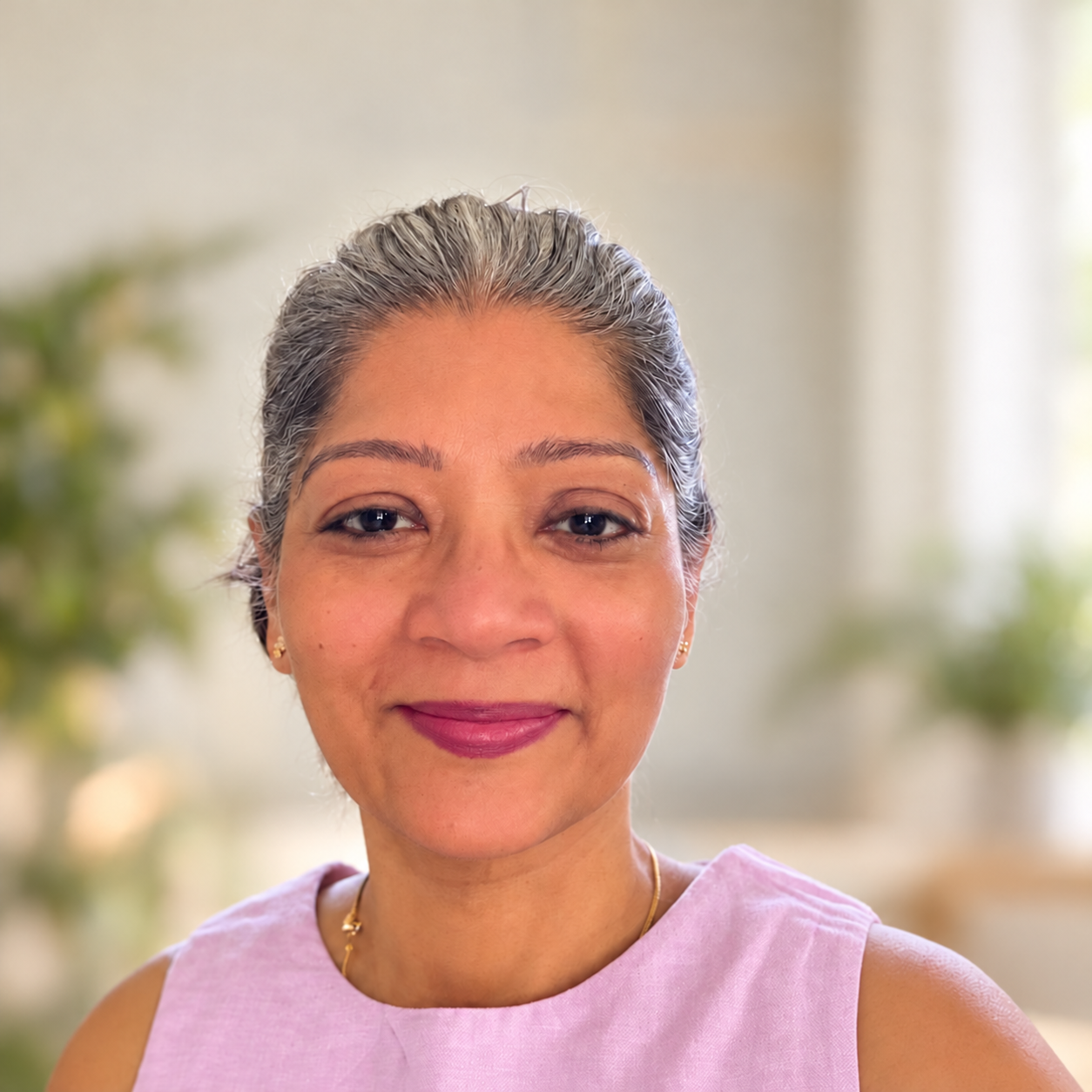 Smiling middle-aged woman with gray hair wearing a pink sleeveless top