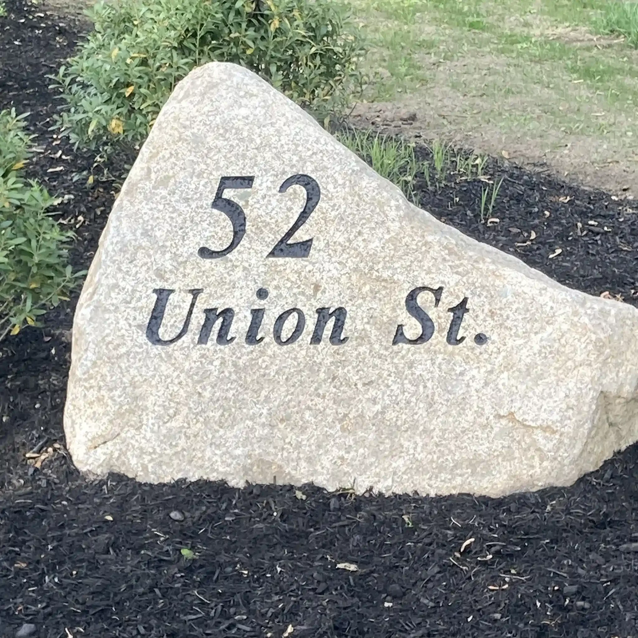 Address boulder with black engraved text.