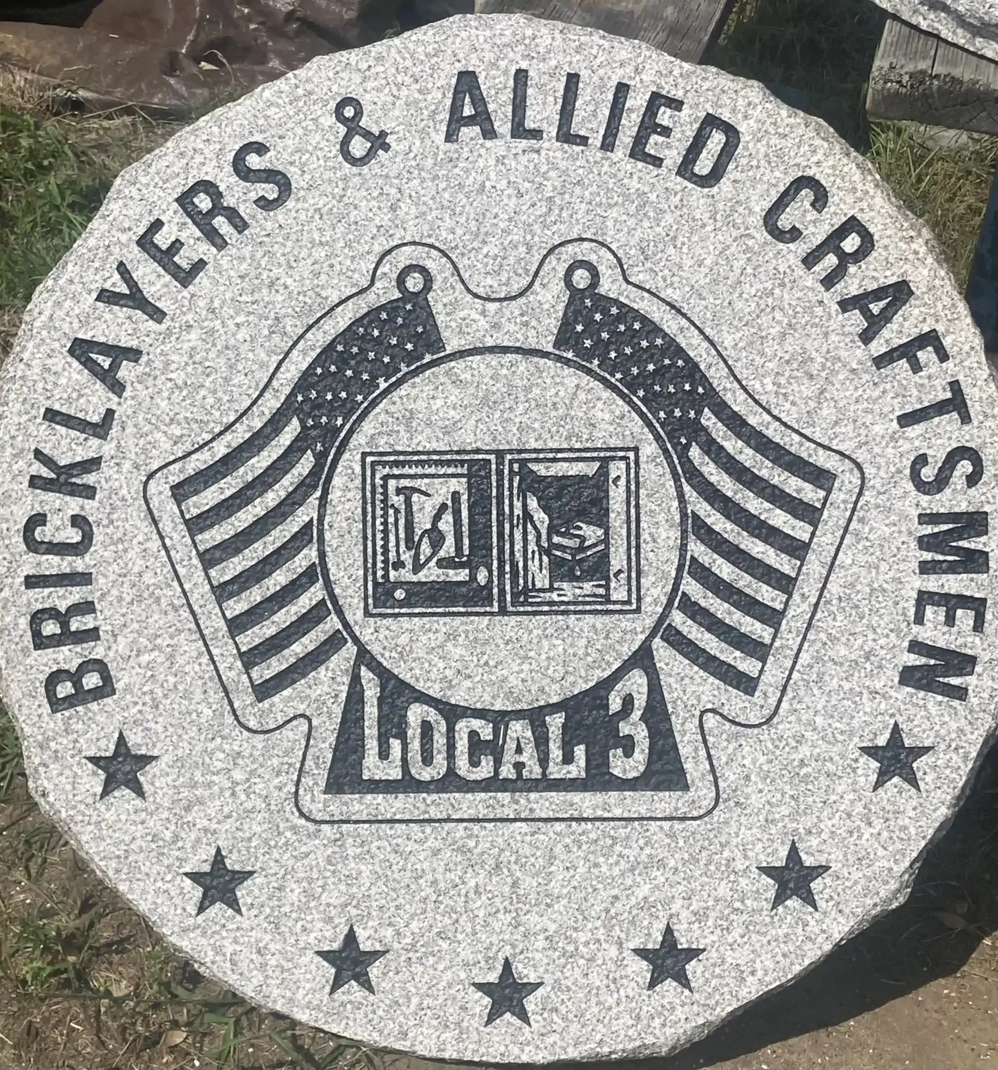 Granite monument with American flag design engraved on it.
