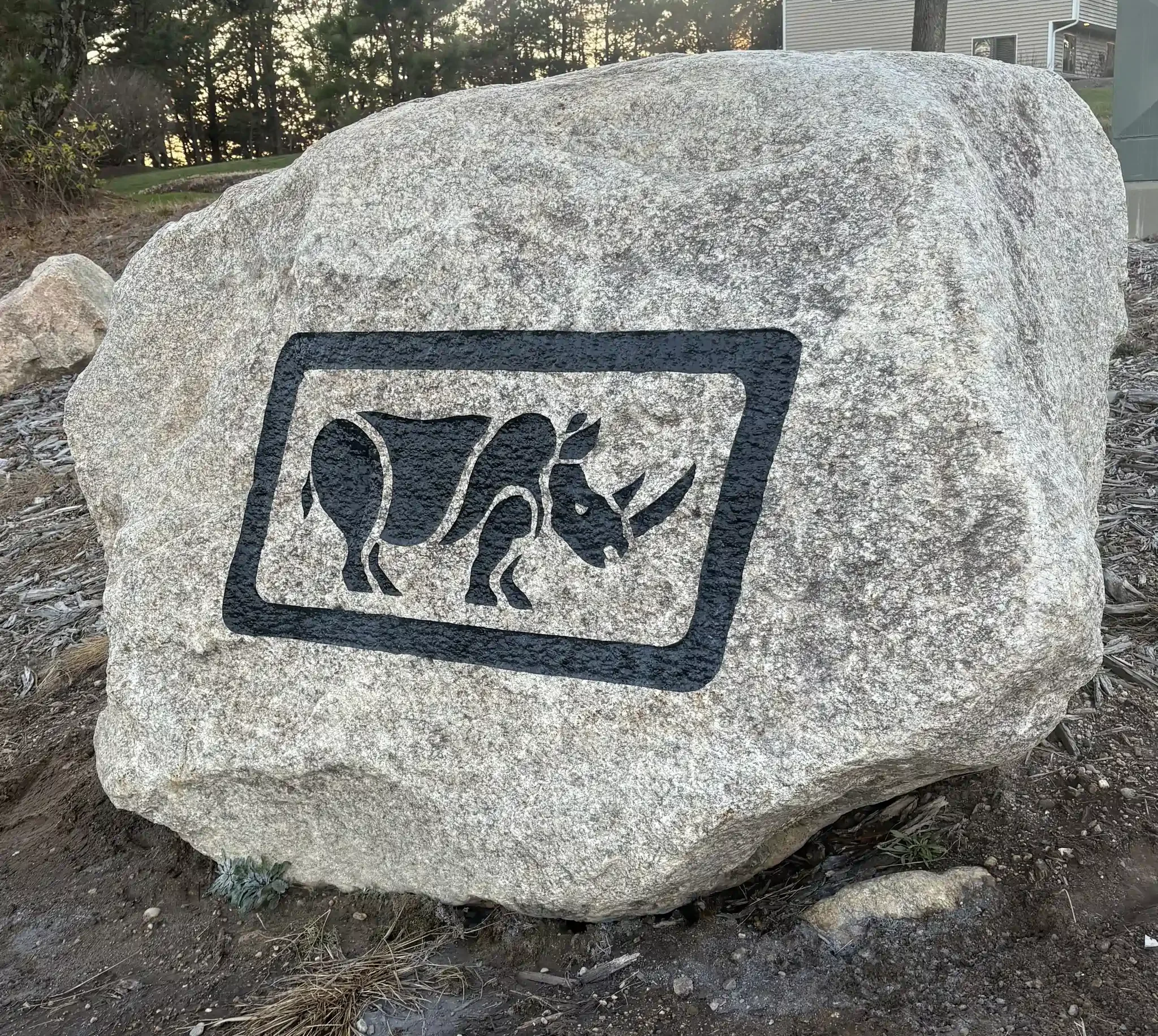 A large gray stone with black engraving.